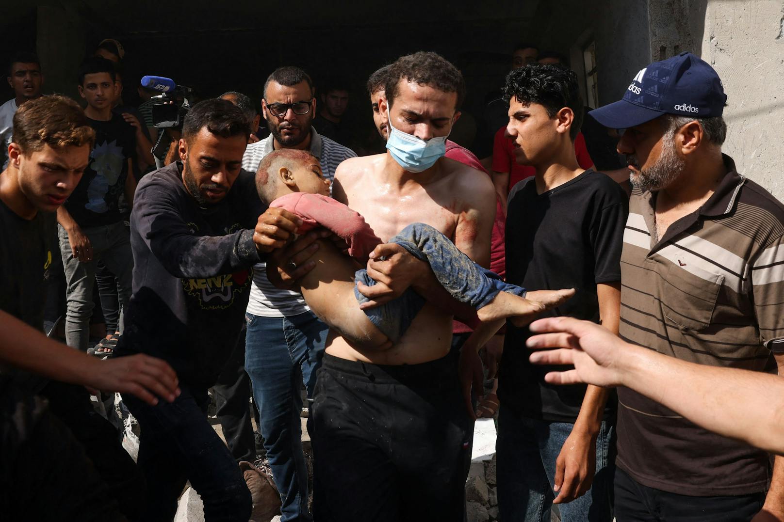 Palästinenser tragen einen Jungen weg während die israelische Armee die Stadt Rafah im südlichen Gazastreifen bombadiert.