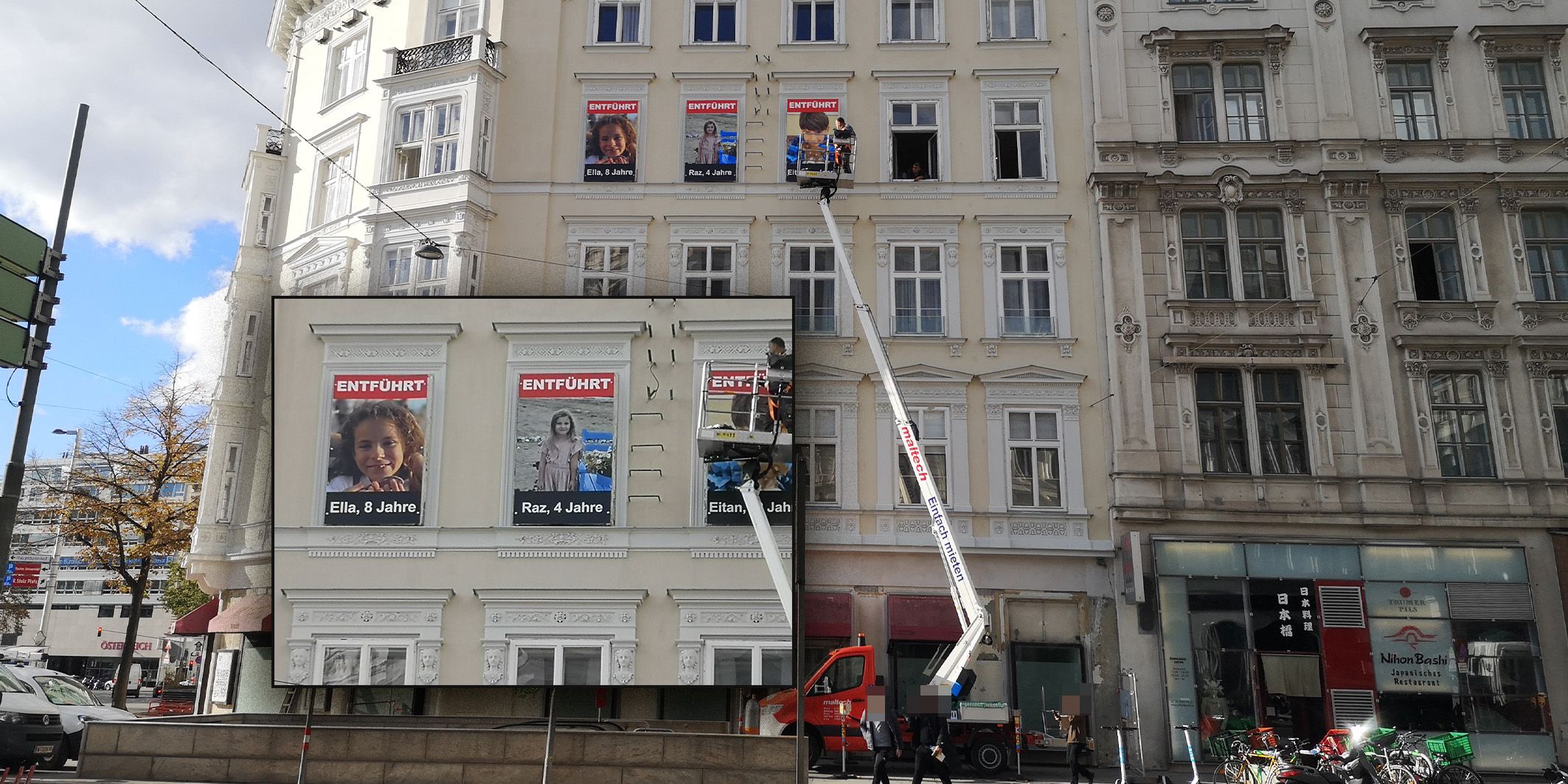 Auf der Außenfassade eines Wohngebäudes in Wien sind seit Mittwoch drei Plakate zu sehen. Diese zeigen junge Entführungsopfer aus Israel.