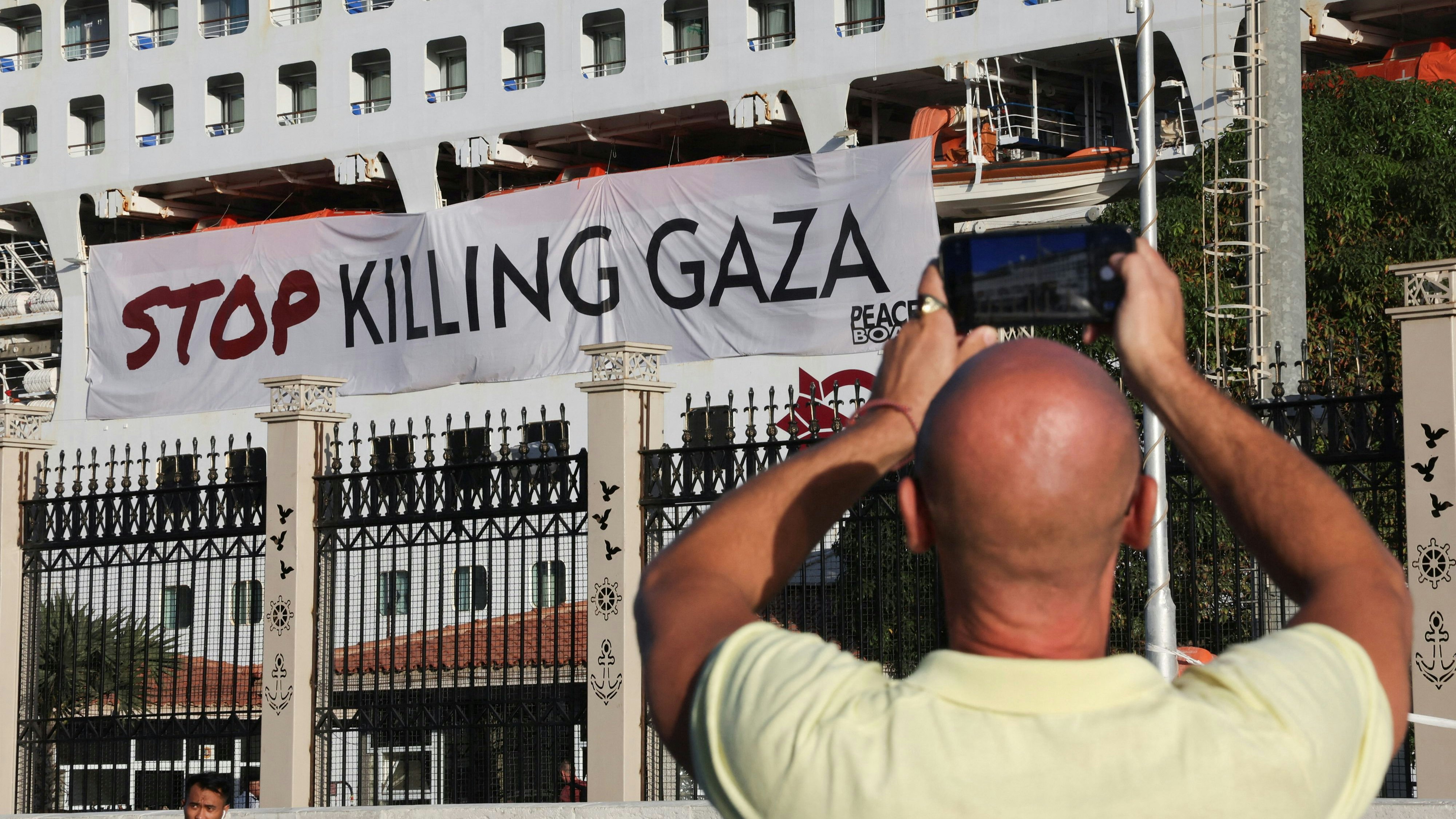 An Egyptian man takes a picture of the Japan-based NGO Peace Boat's cruise ship Pacific World, which displays a banner reading "Stop Killing Gaza", while traveling a global cruise and calling for a ceasefire in Gaza, amid the ongoing conflict between Israel and the Palestinian Islamist group Hamas, at the port of the Mediterranean terminus of the Suez Canal, in Port Said, Egypt November 8, 2023. REUTERS/Amr Abdallah Dalsh