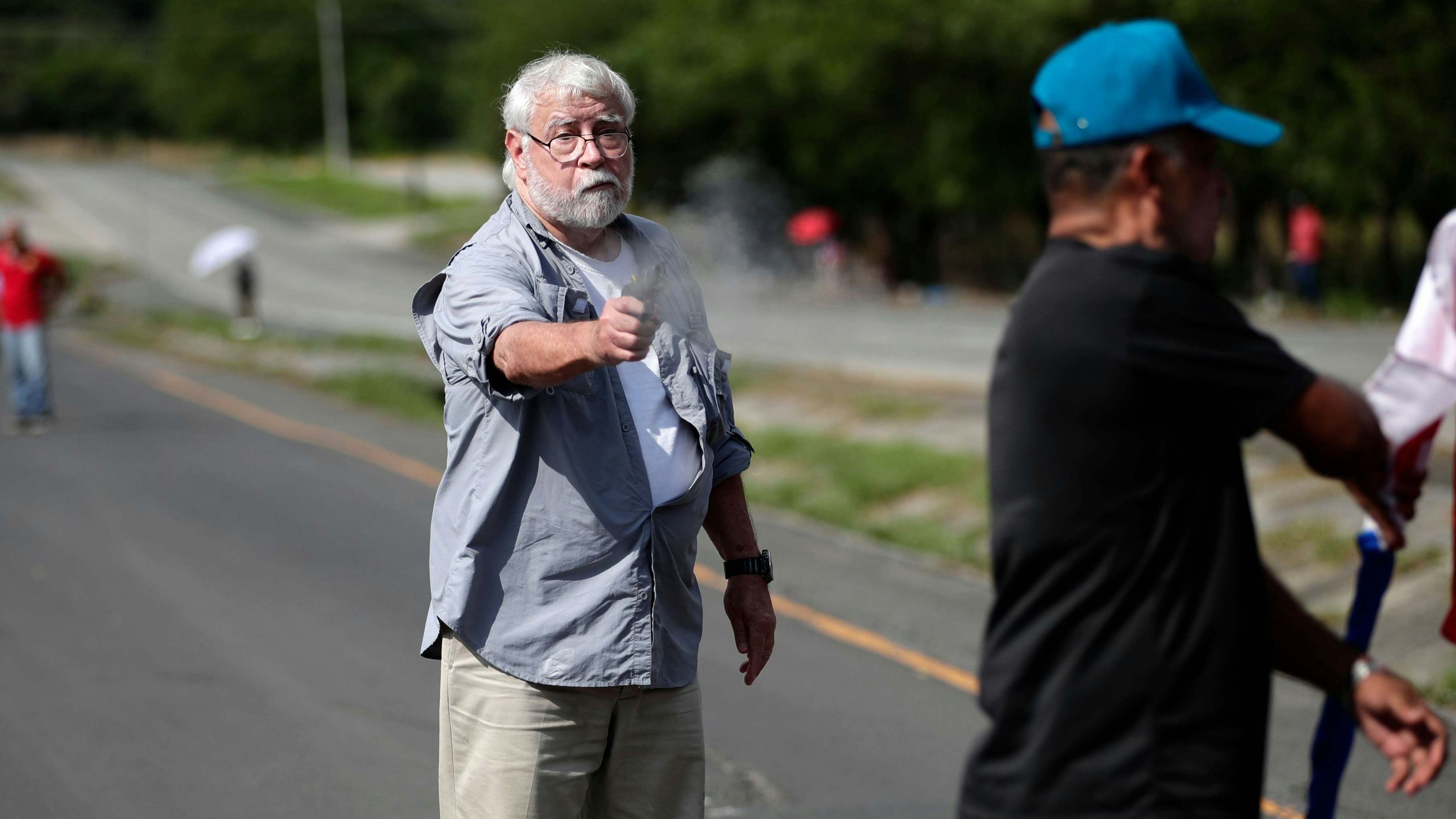 epa10963547 A man shoots a protester with a gun after walking up to a teachers' blockade on the Pan-American Highway in Chame, Panama, 07 November 2023. An armed man shot at protesters blocking a road as part of anti-mining protest that have been taking place for two weeks in Panama, killing two people, EFE confirmed at the scene.  EPA-EFE/Bienvenido Velasco ATTENTION EDITORS GRAPHIC CONTENT
