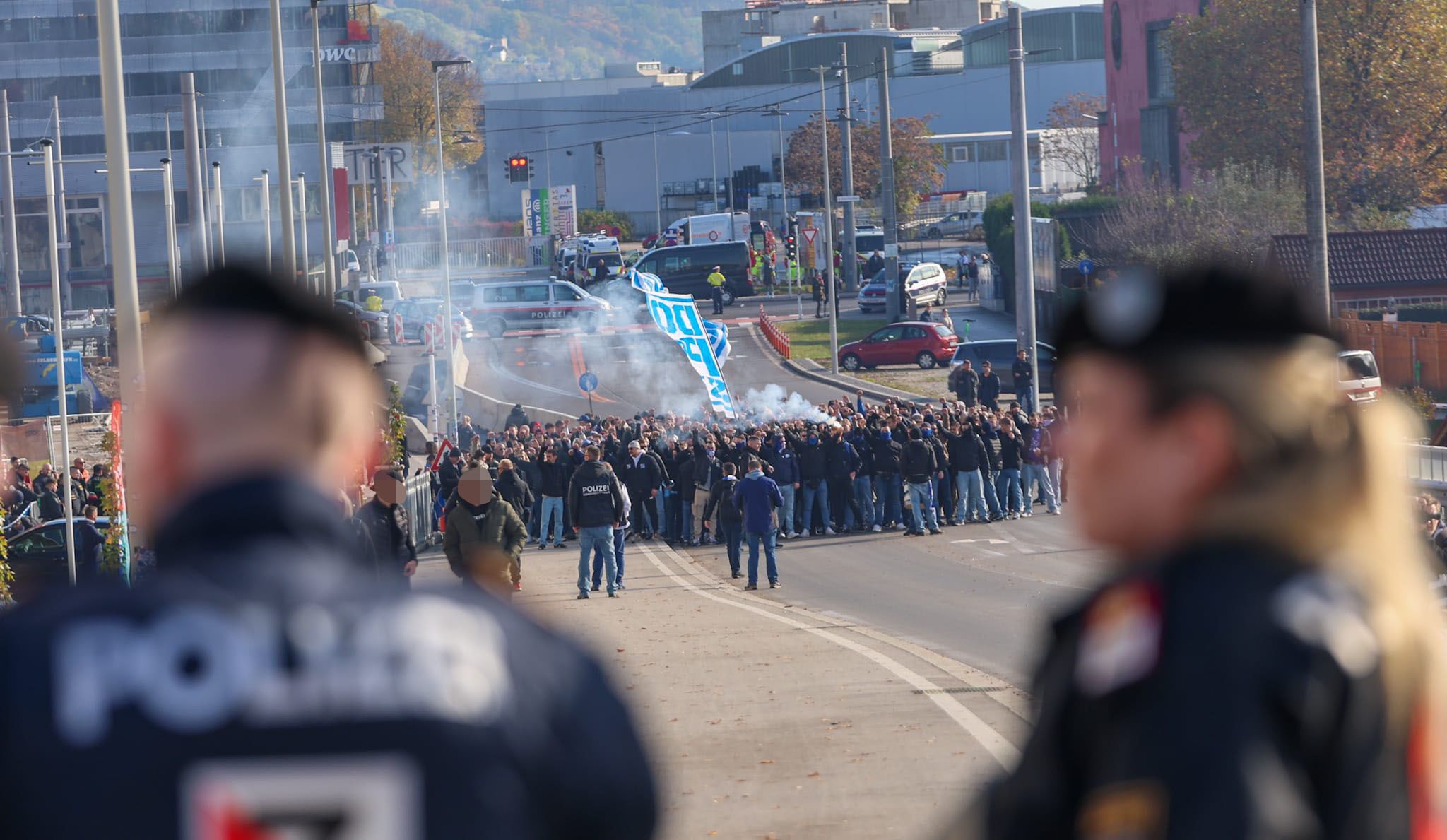 Fans von Blau Weiß Linz vor dem Hofmann Personal Stadion. Im Vordergrund Polizei-Beamte.