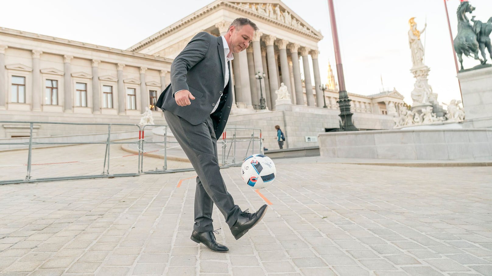 SPÖ-Chef Andreas Babler gaberlt mit einem Fußball vor dem Parlament.