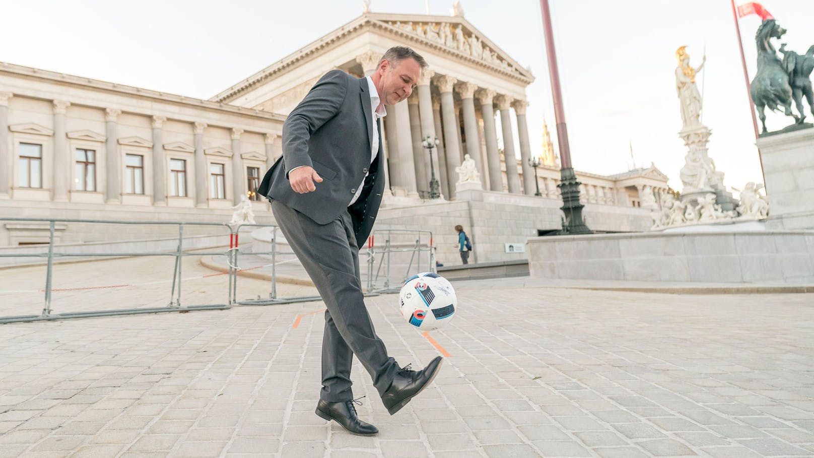 SPÖ-Chef Andreas Babler gaberlt mit einem Fußball vor dem Parlament.