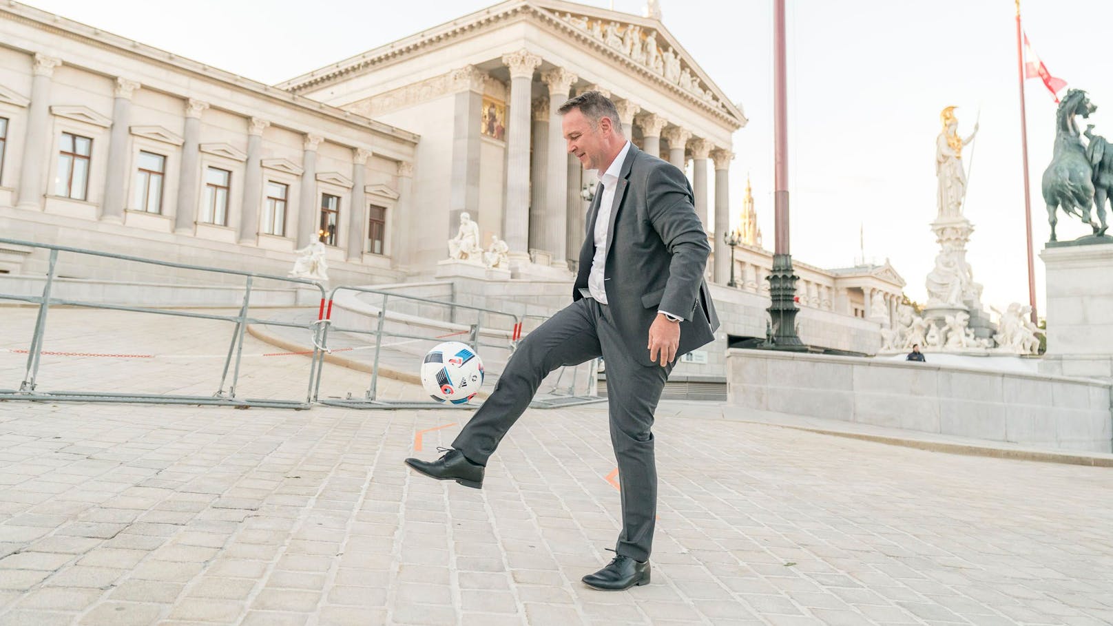 SPÖ-Chef Andreas Babler gaberlt mit einem Fußball vor dem Parlament.