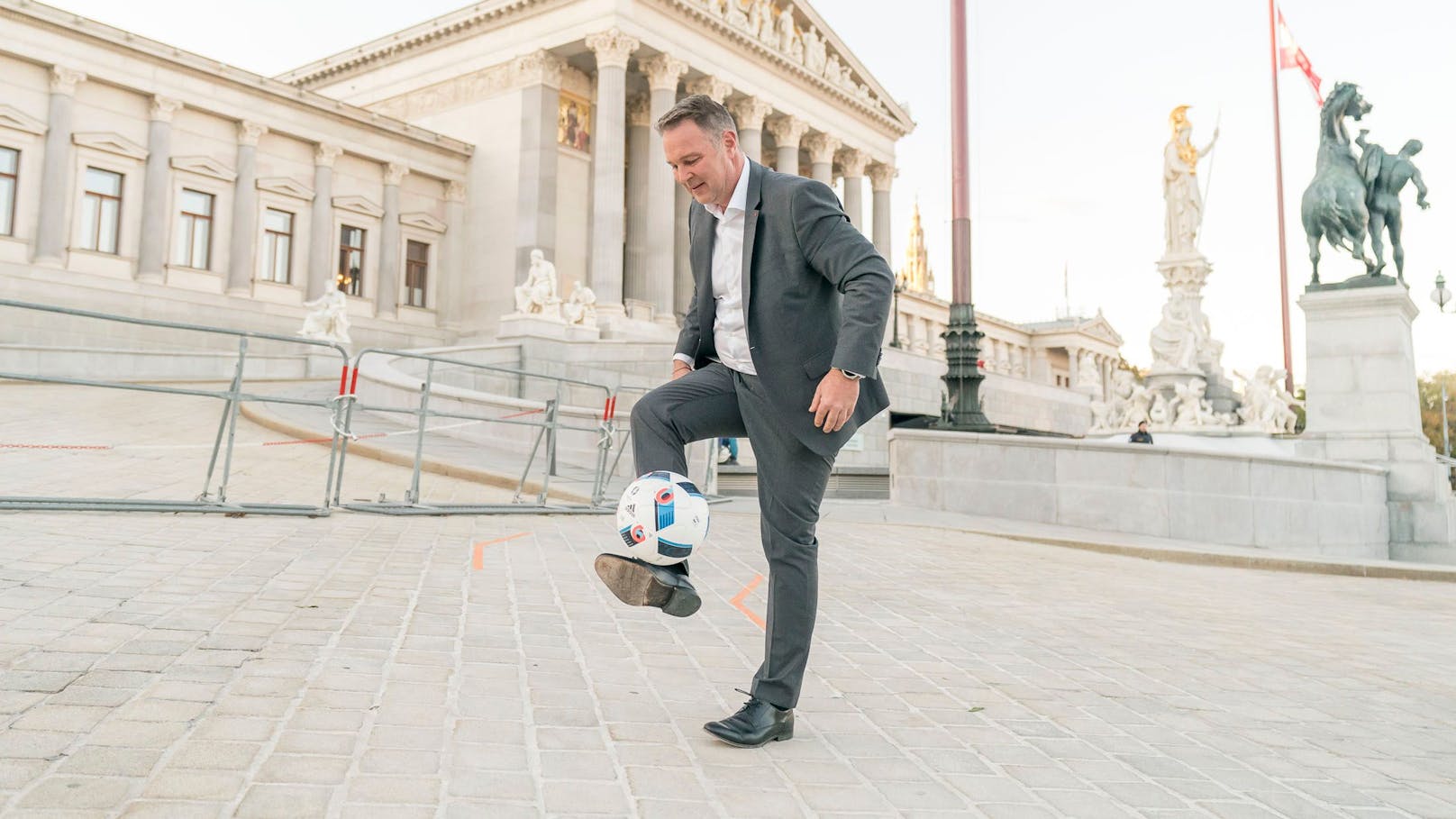 SPÖ-Chef Andreas Babler gaberlt mit einem Fußball vor dem Parlament.