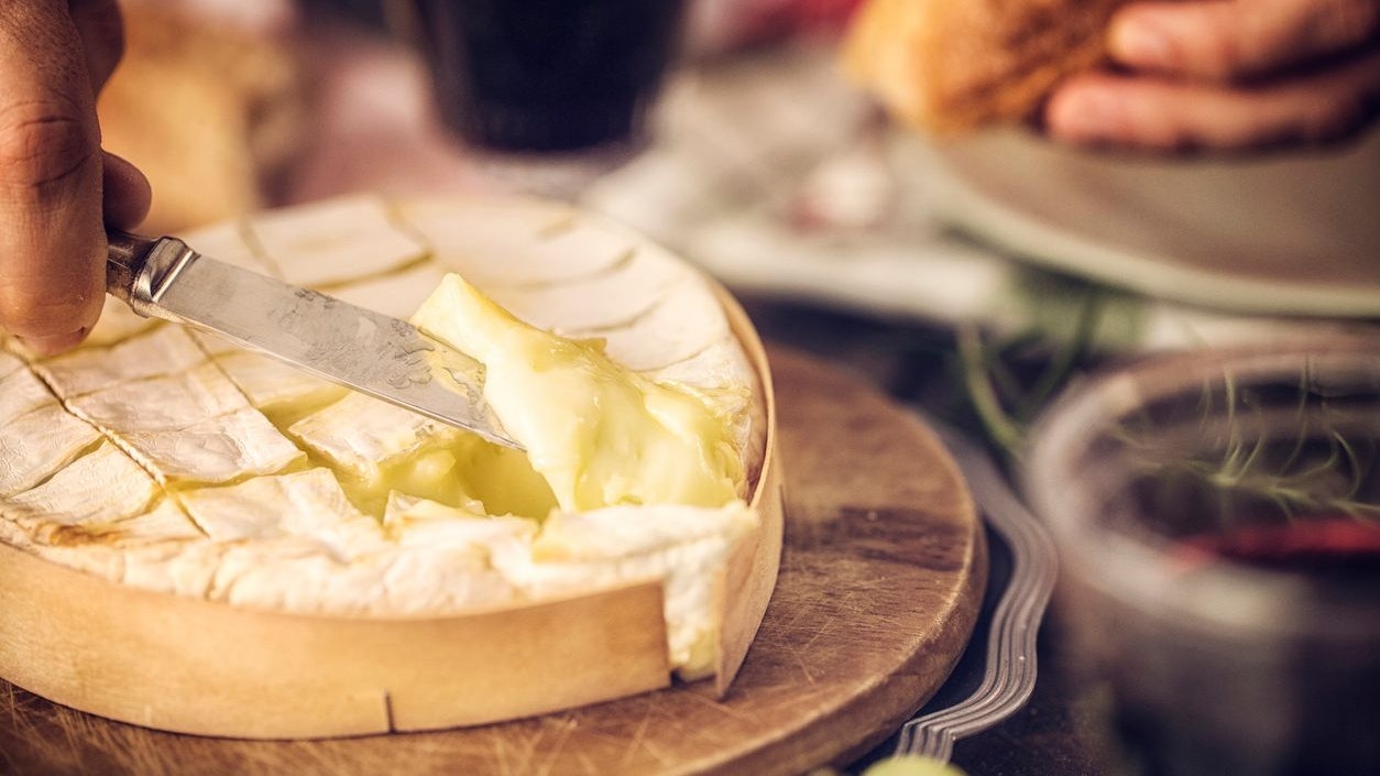 Baked Camembert cheese with garlic and rosemary. This soft, creamy and surface-ripened milk cheese is a delicious snack.