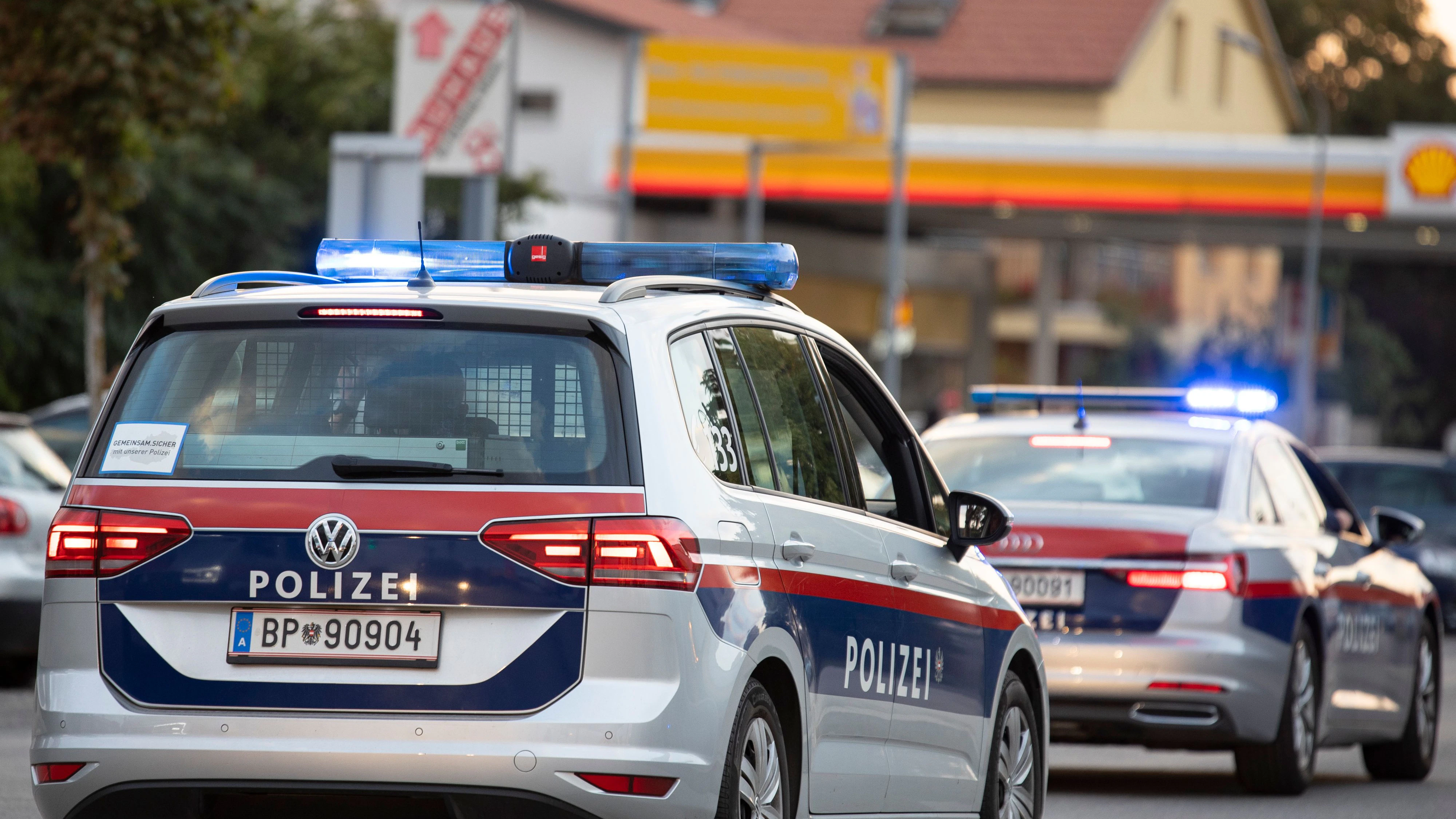 Symbol- und Archivbildes von Polizeieinsatzfahrzeugen vor einer Tankstelle. 