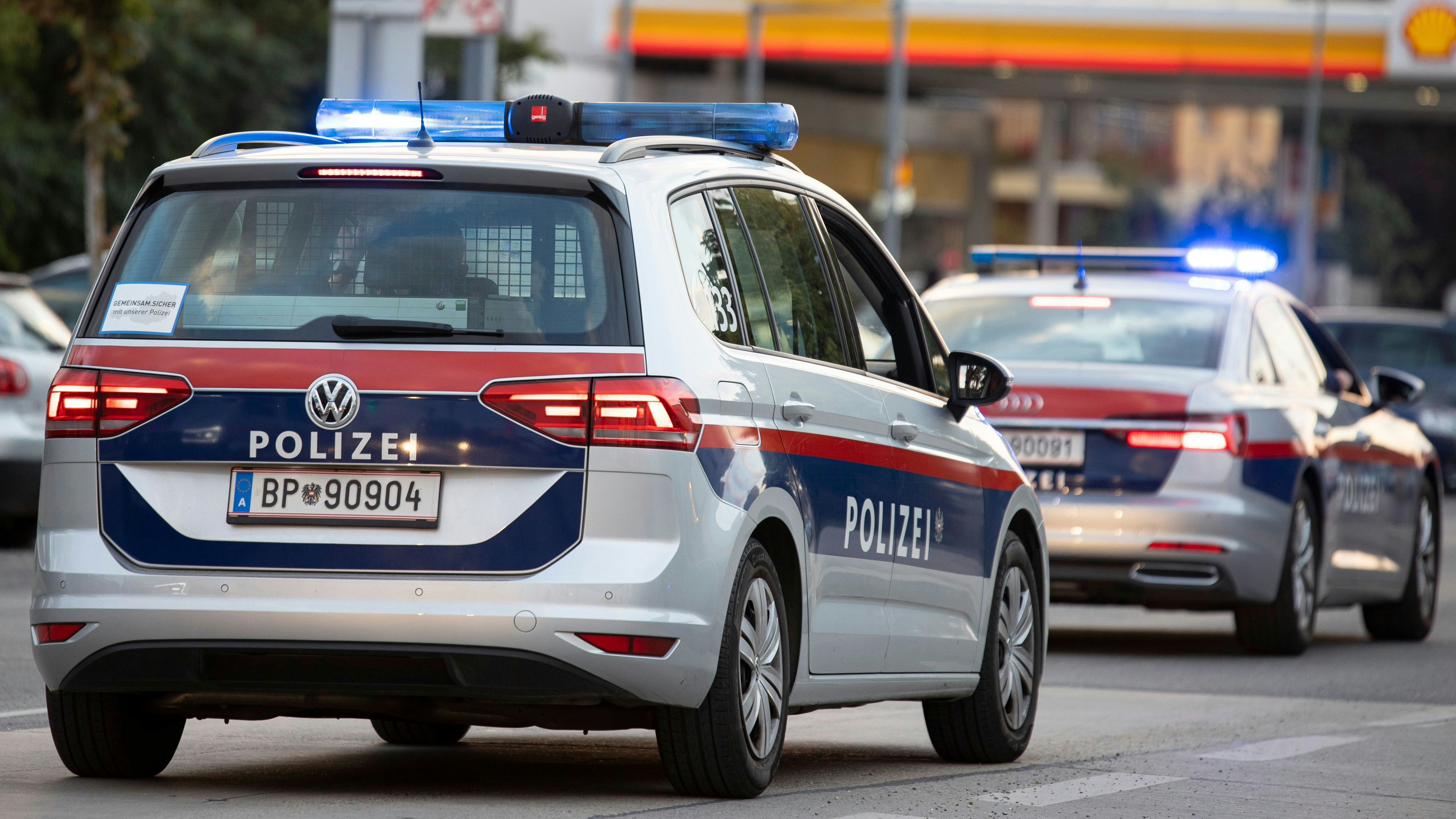 Symbol- und Archivbildes von Polizeieinsatzfahrzeugen vor einer Tankstelle. 