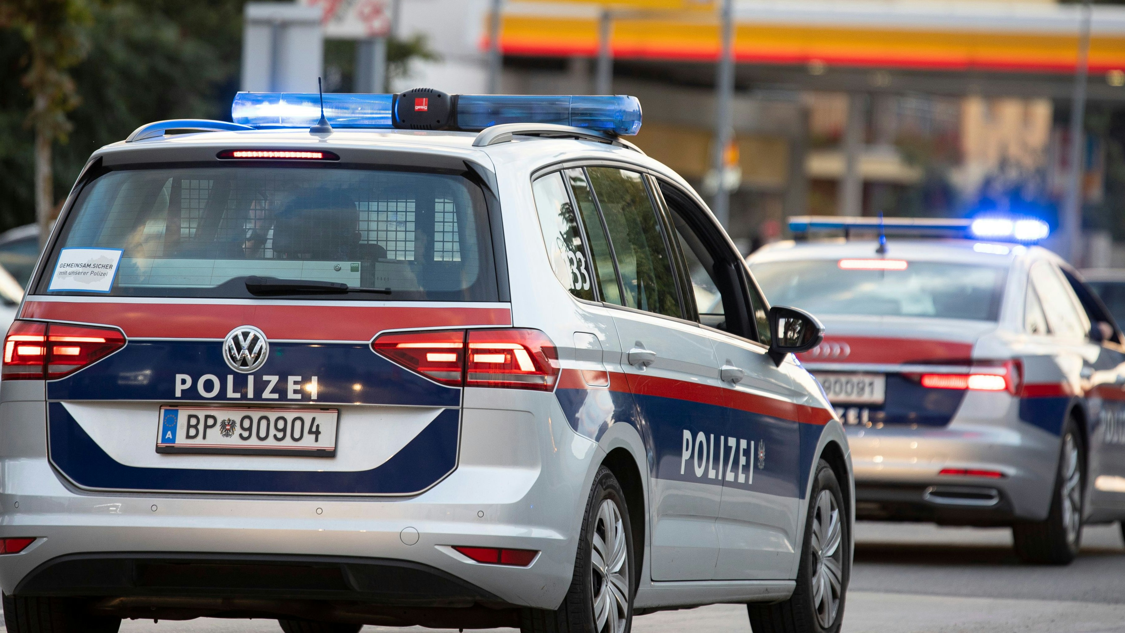 Symbol- und Archivbildes von Polizeieinsatzfahrzeugen vor einer Tankstelle. 