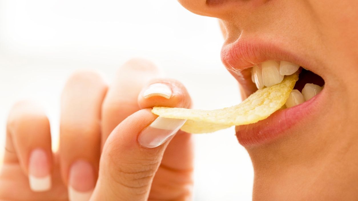 Close-up of a woman biting potato chips, selective focus, canon 1Ds mark III