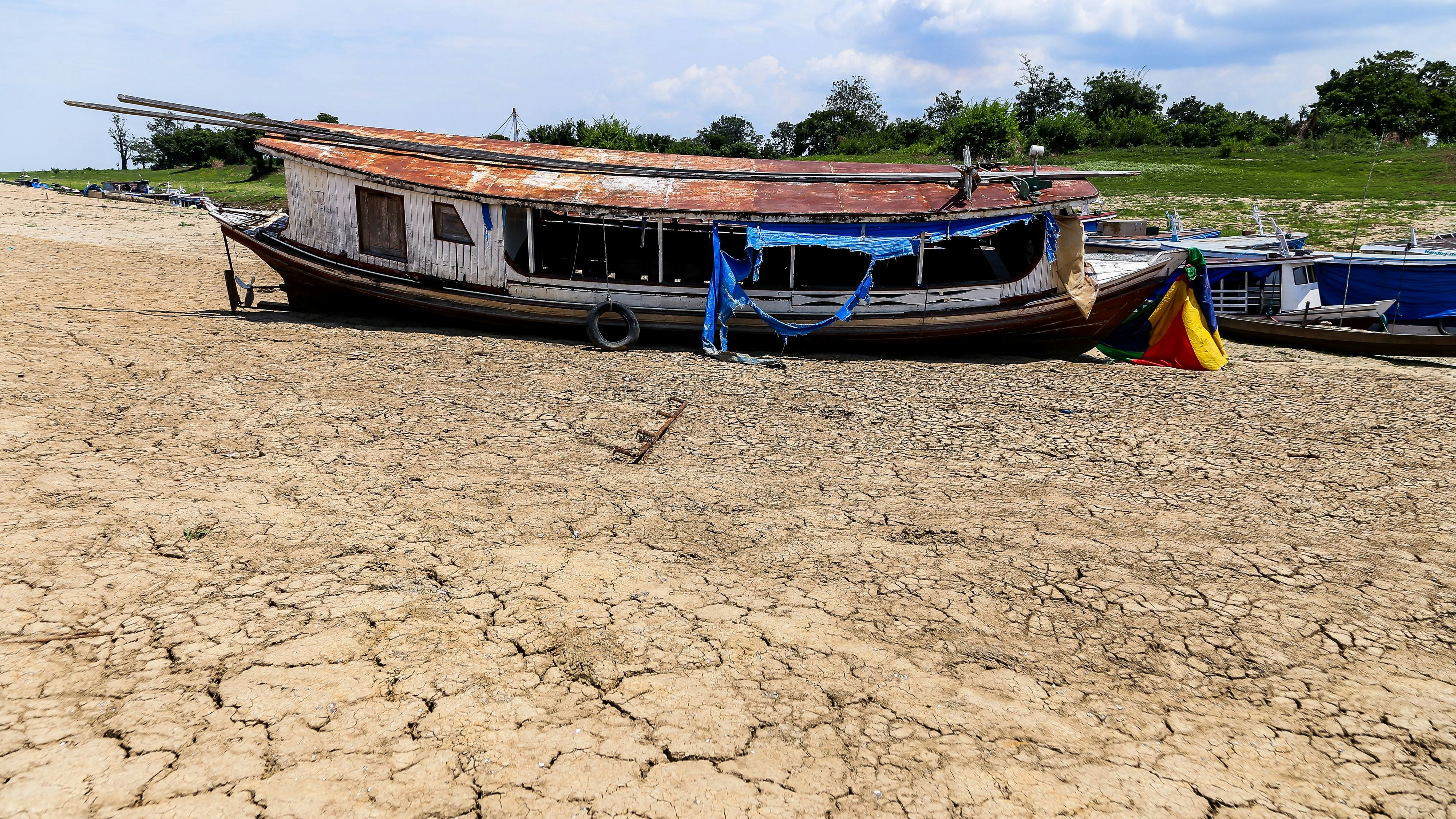Download von www.picturedesk.com am 20.11.2023 (10:22).  PRODUCTION - 08 November 2023, Brazil, Parintins: Boats stranded due to drought lie on the edge of the dried-up Laguna da Francesa. The green lung of the planet, the Amazon basin in South America, is experiencing an unprecedented crisis. The largest rainforest area in the world is suffering from the worst drought in over a century. Photo: Aguilar Abecassis/dpa - 20231108_PD21767 - Rechteinfo: Rights Managed (RM)