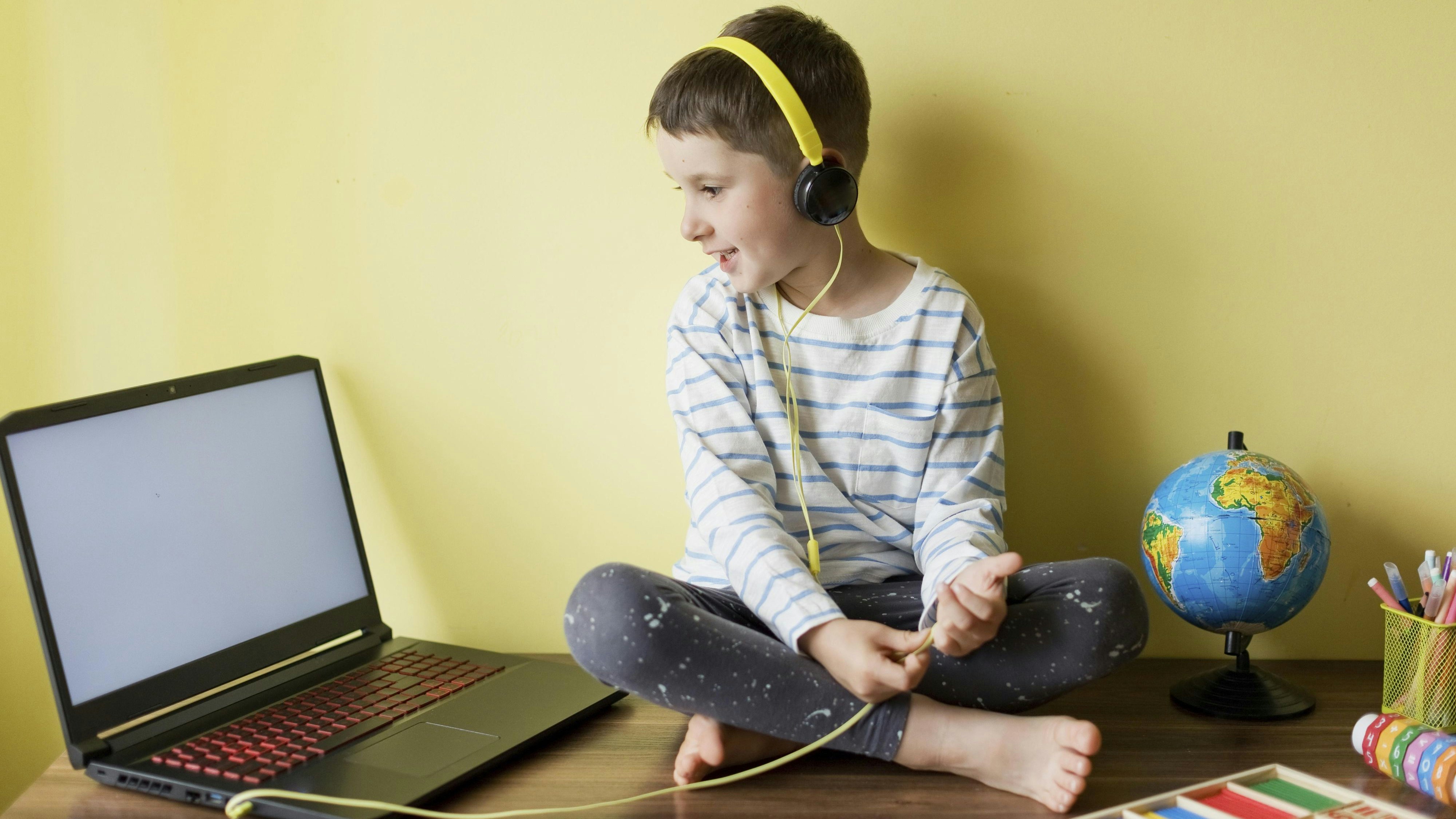Download von www.picturedesk.com am 21.11.2023 (14:17).  Smiling boy wearing headphones during homeschooling - 20220920_PD18452 - Rechteinfo: Royalty Free (RF) Model Released