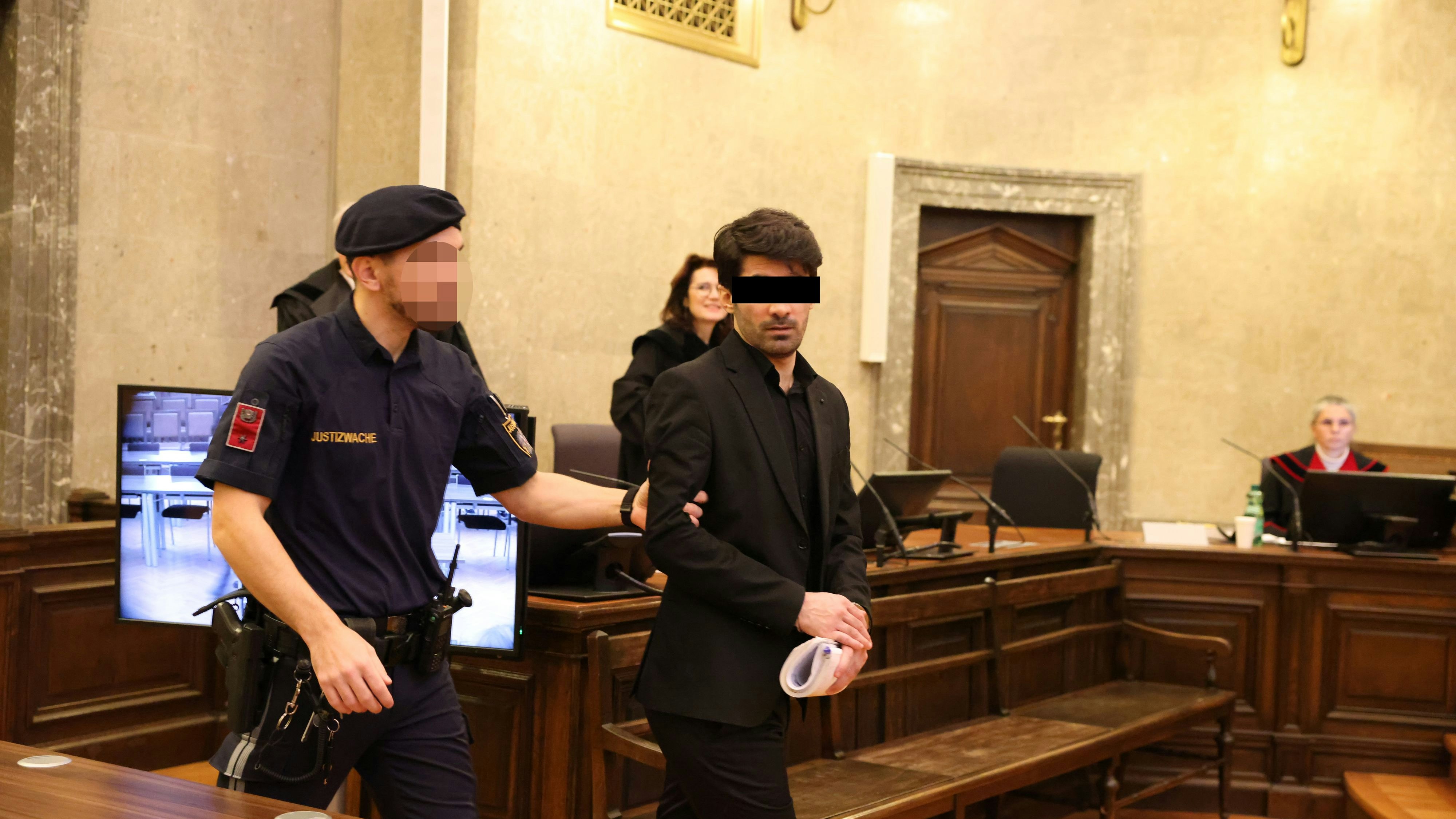 Yusof A. (35) – ganz in schwarz – wird von einem Justizwachebeamten in den großen Schwurgerichtssaal geführt.