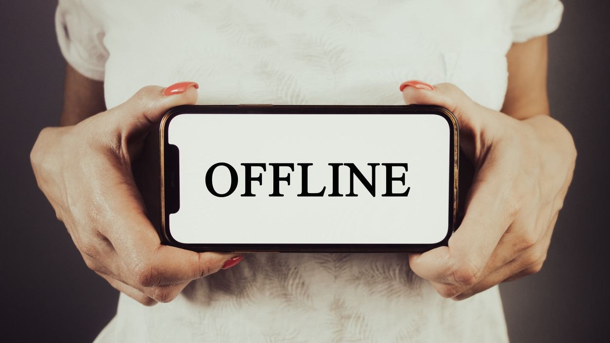 Woman holding phone with word offline. Internet connection, streaming concept
