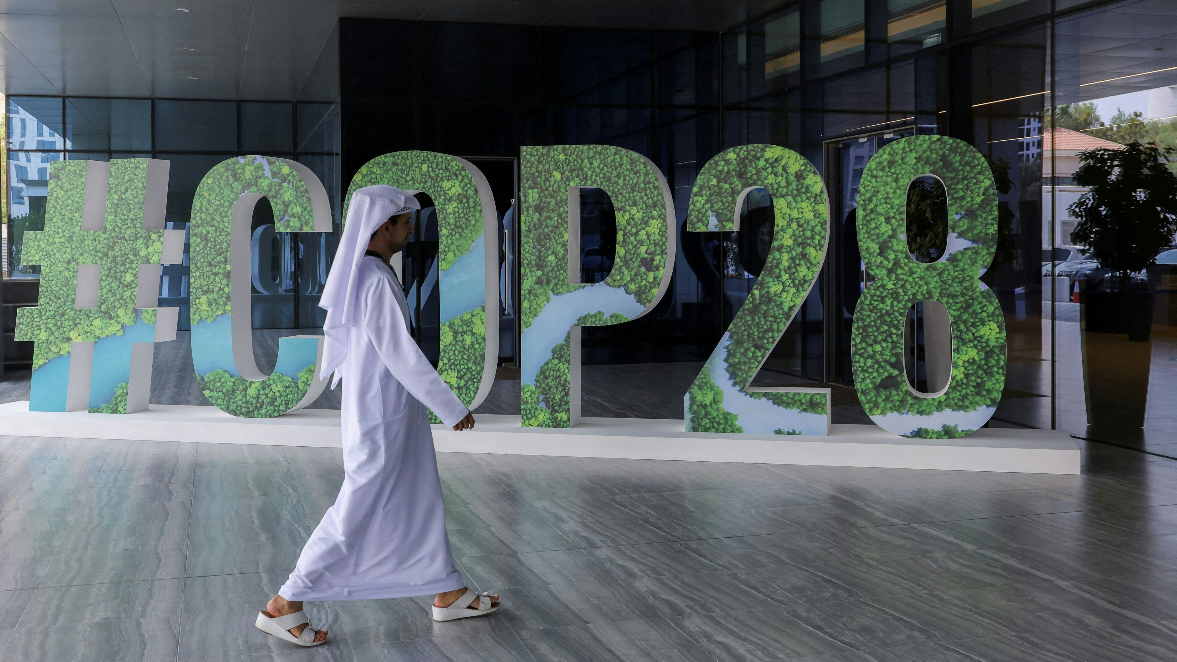 FILE PHOTO: A person walks past a "#COP28" sign during The Changemaker Majlis, a one-day CEO-level thought leadership workshop focused on climate action, in Abu Dhabi, United Arab Emirates, October 1, 2023. REUTERS/Amr Alfiky/File Photo