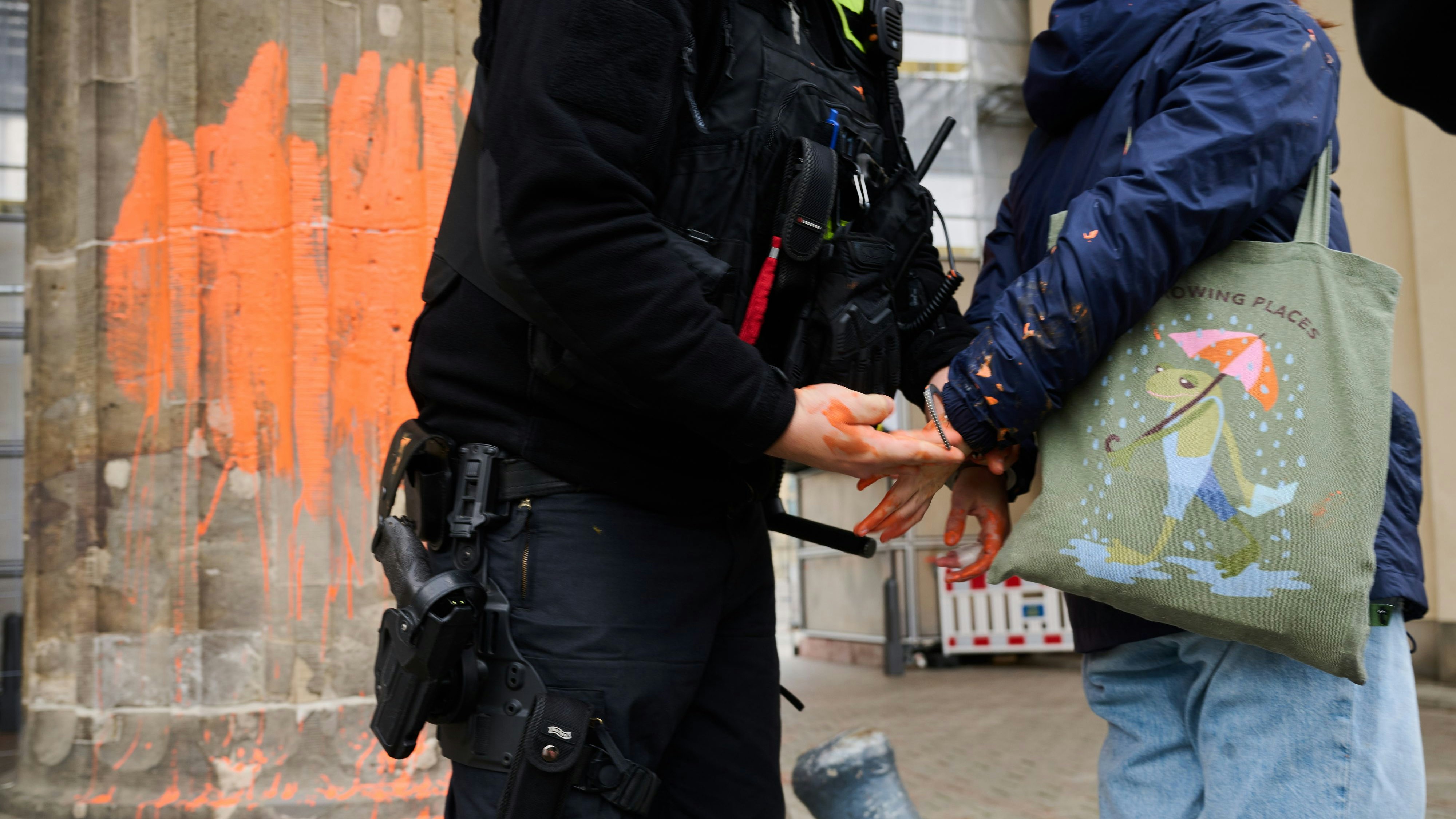 Download von www.picturedesk.com am 24.11.2023 (10:47).  16 November 2023, Berlin: A police officer takes a climate activist into custody for painting the Brandenburg Gate with orange paint. The Last Generation group announced on Thursday that members had painted the west side of the building with paintbrushes. The Berlin police reported that two climate activists were arrested. Photo: Annette Riedl/dpa - 20231116_PD5998 - Rechteinfo: Rights Managed (RM)