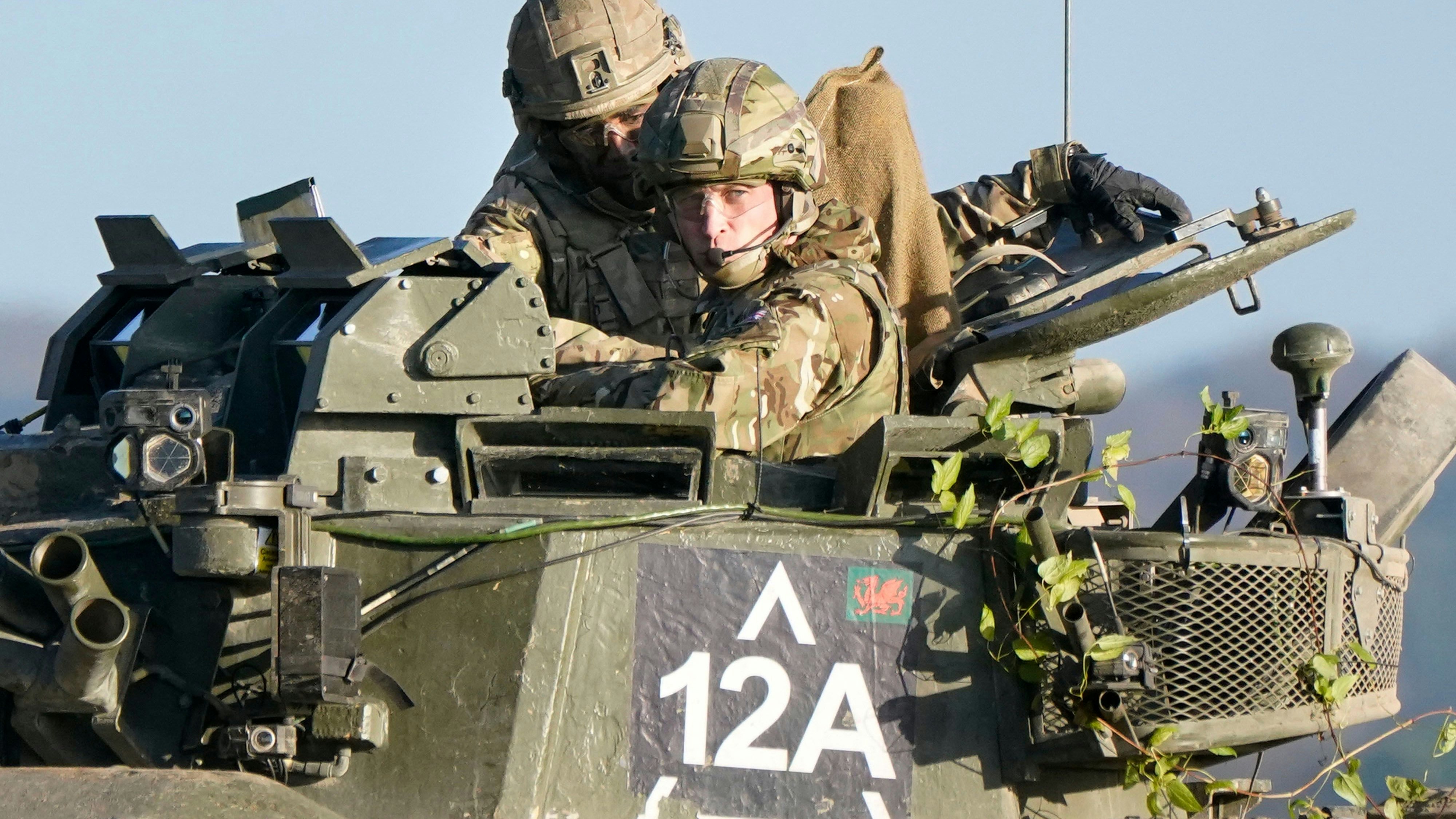 Der britische Prinz William, Prinz von Wales (R), fährt in seiner Funktion als Oberst des 1. Bataillons des Mercian-Regiments in einem gepanzerten Kampffahrzeug Warrior mit, während er bei einem Besuch des Regiments in der Nähe von Salisbury im Südwesten Englands am 23. November 2023 eine Trainingsübung beobachtet.