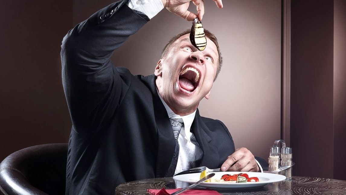 Muscular businessman eating and lick the plate