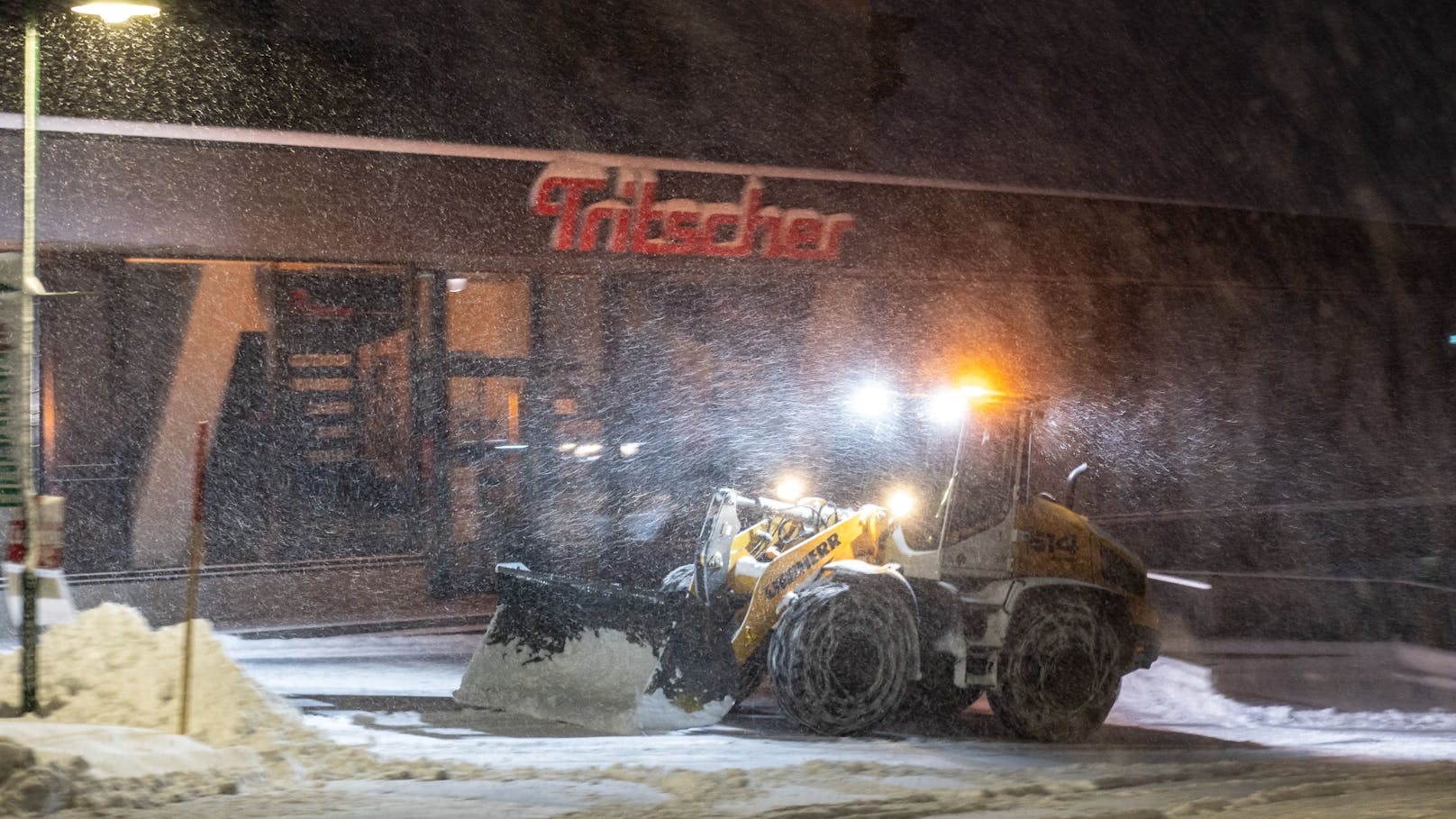 Das Tiefdruckgebiet Niklas sorgten im oberen Ennstal in der Nacht vom 24. auf den 25. November für Neuschnee. Im Bild ein Einsatzfahrzeug bei Schneeräumarbeiten in der Morgendämmerung, aufgenommen in Rohrmoos bei Schladming.