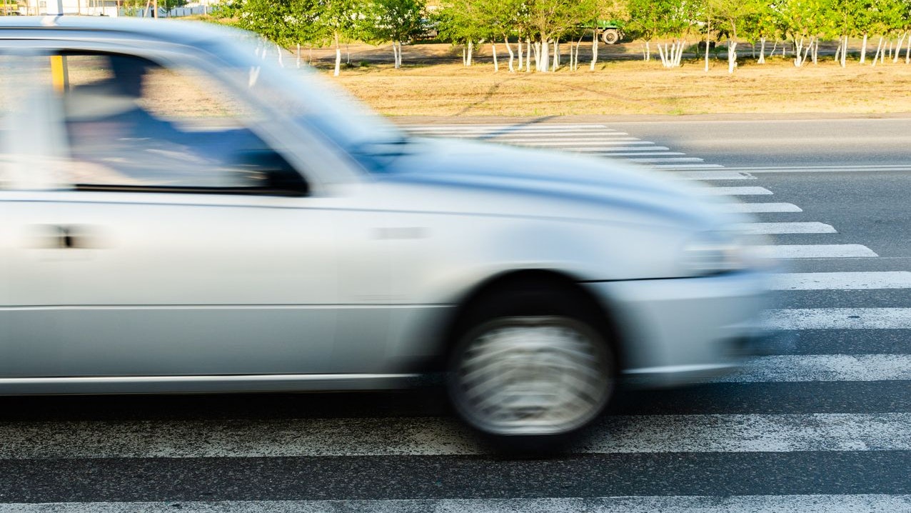 Car at high speed passes through a pedestrian Zebra.