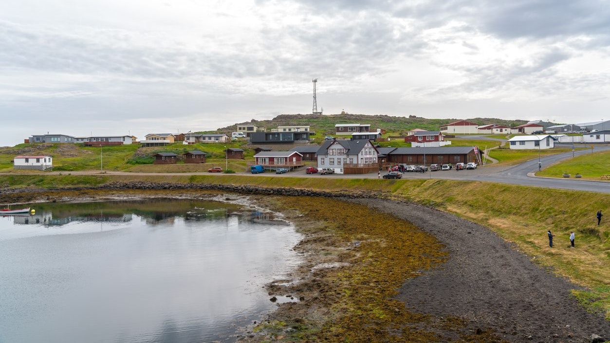 Djupivogur, Iceland - 26 july, 2021; Town at fjord Berufjörður, traditional houses at the coast, some people cleaning the grass at the beach. Eastern Iceland