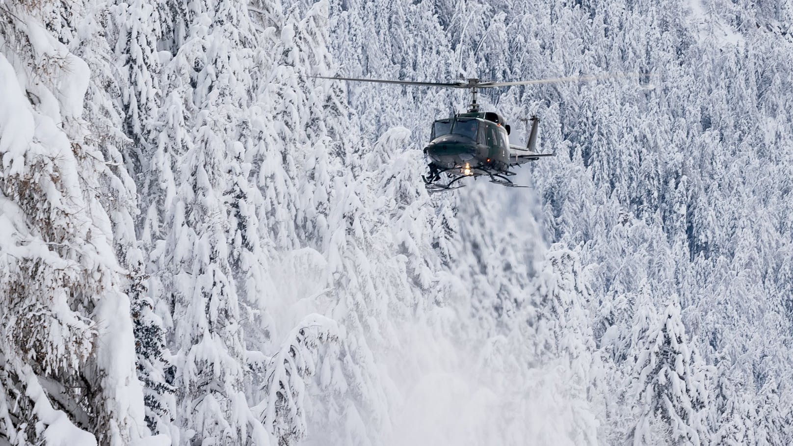 Eine Agusta Bell 212 des Bundesheeres im Kampf gegen den Schnee bei einem sogenannten Downwash-Manöver. Die Rotor-Abwinde werden bei niedrigem Überflug genutzt, um Schnee von Bäumen zu schütteln. Archivbild.