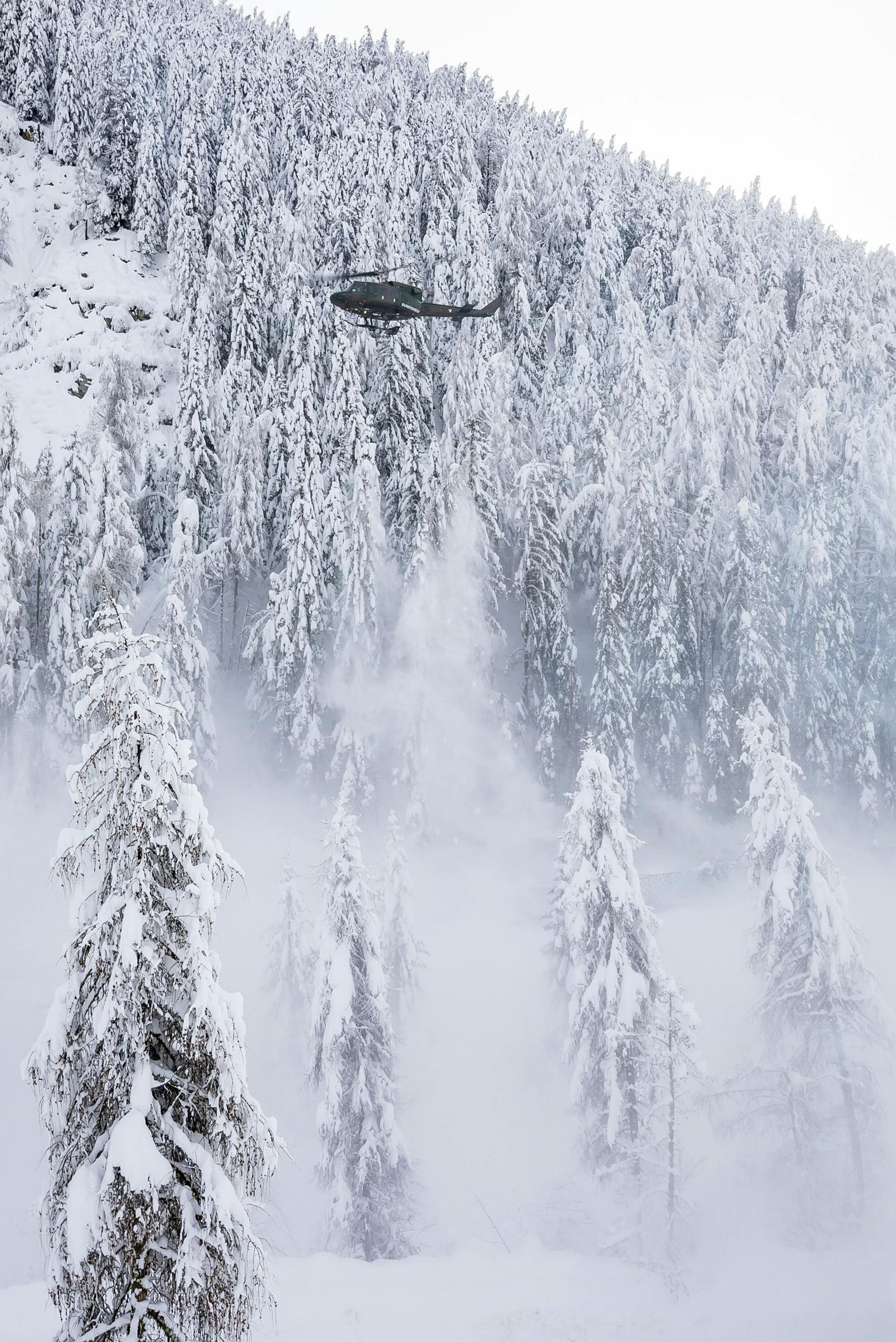 Eine Agusta Bell 212 des Bundesheeres im Kampf gegen den Schnee bei einem sogenannten Downwash-Manöver. Die Rotor-Abwinde werden bei niedrigem Überflug genutzt, um Schnee von Bäumen zu schütteln. Archivbild.