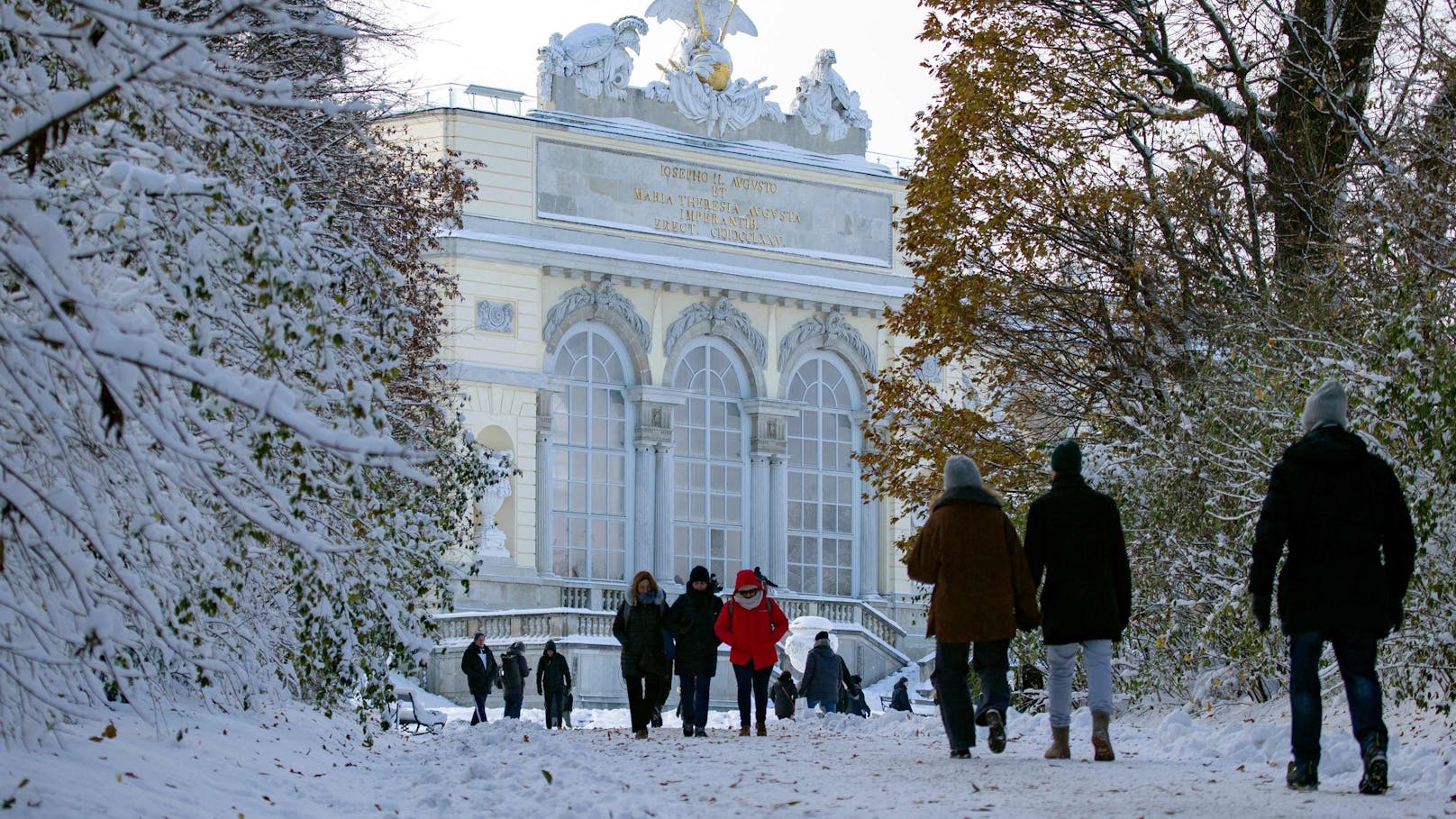Besucher vor der verschneiten Gloriette am 3. Dezember 2023.