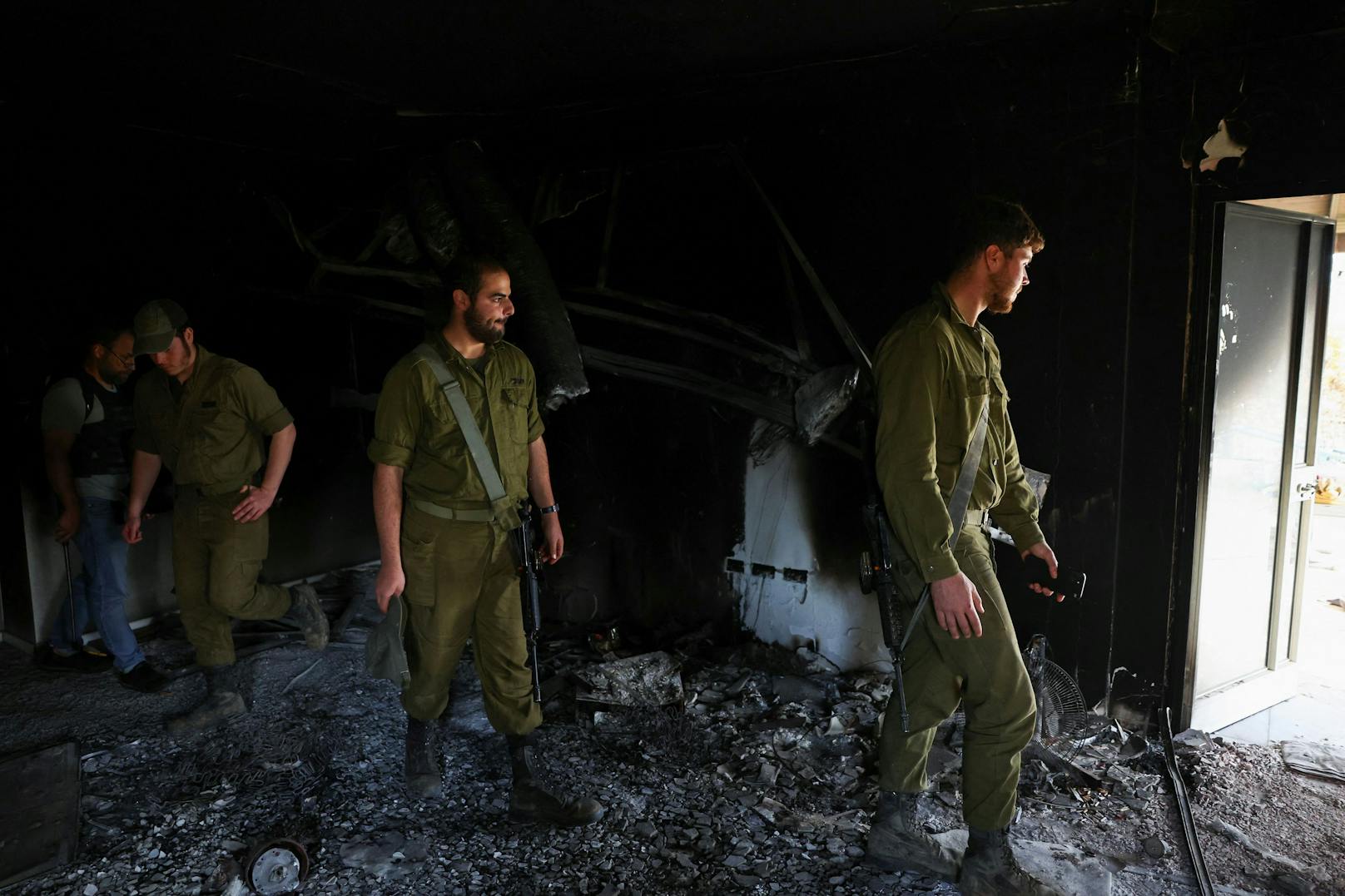 Israelische Soldaten inspizieren ein niedergebranntes Haus im Kibbutz Beeri im Süden Israels.