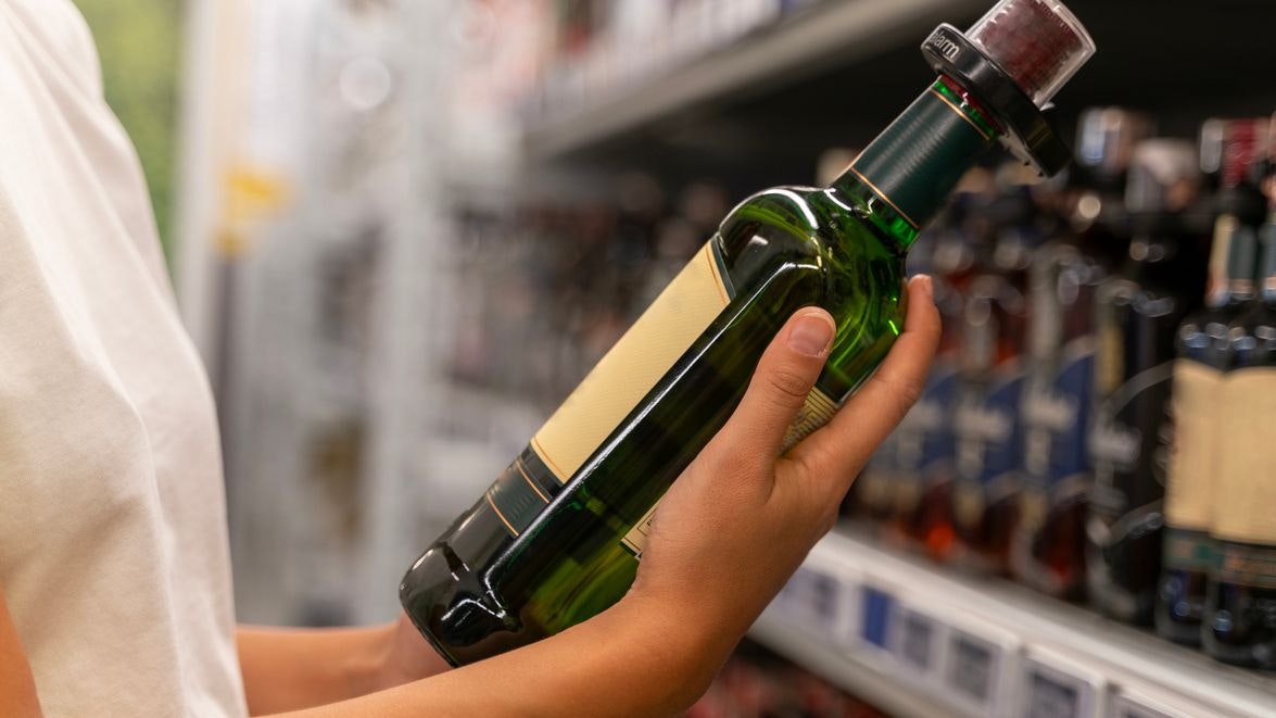 Woman looking for wine in the beverage aisle of the supermarket