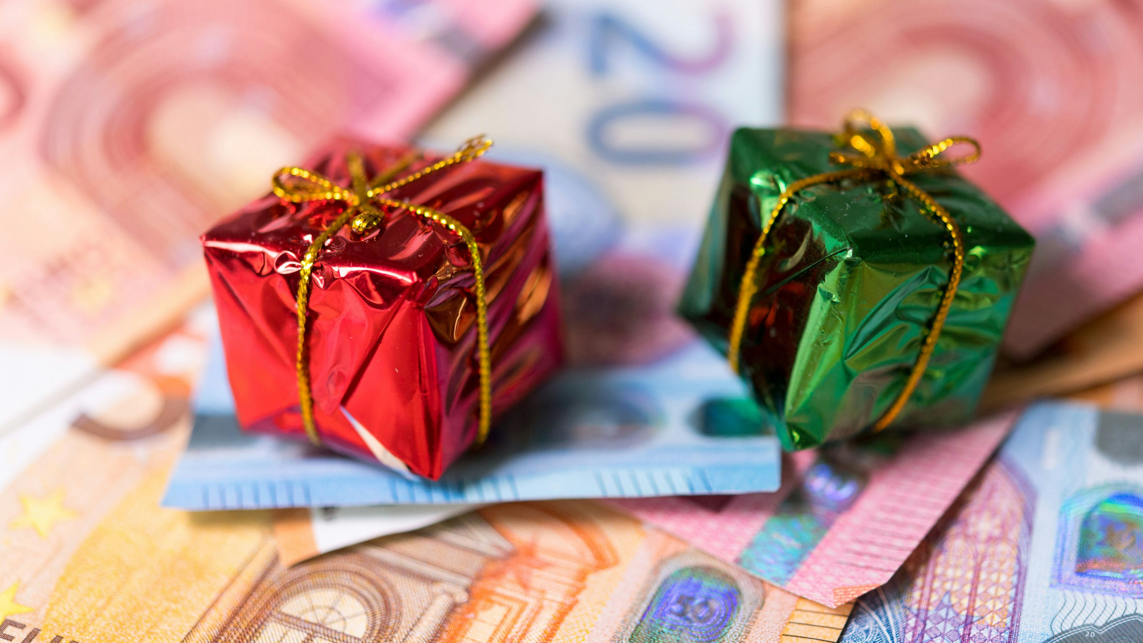 Download von www.picturedesk.com am 12.12.2023 (16:35).  ABD0072_20191104 - DRESDEN - DEUTSCHLAND: ARCHIV - 04.12.2018, Sachsen, Dresden: ILLUSTRATION - Zwei kleine Geschenke liegen auf zahlreichen Banknoten. (zu dpa "Weihnachtsgeld für die meisten Tarifbeschäftigten" am 04.11.2019) Foto: Monika Skolimowska/zb/dpa +++ dpa-Bildfunk +++. - FOTO: APA/zb/Monika Skolimowska - 20181204_PD15530 - Rechteinfo: Rights Managed (RM)