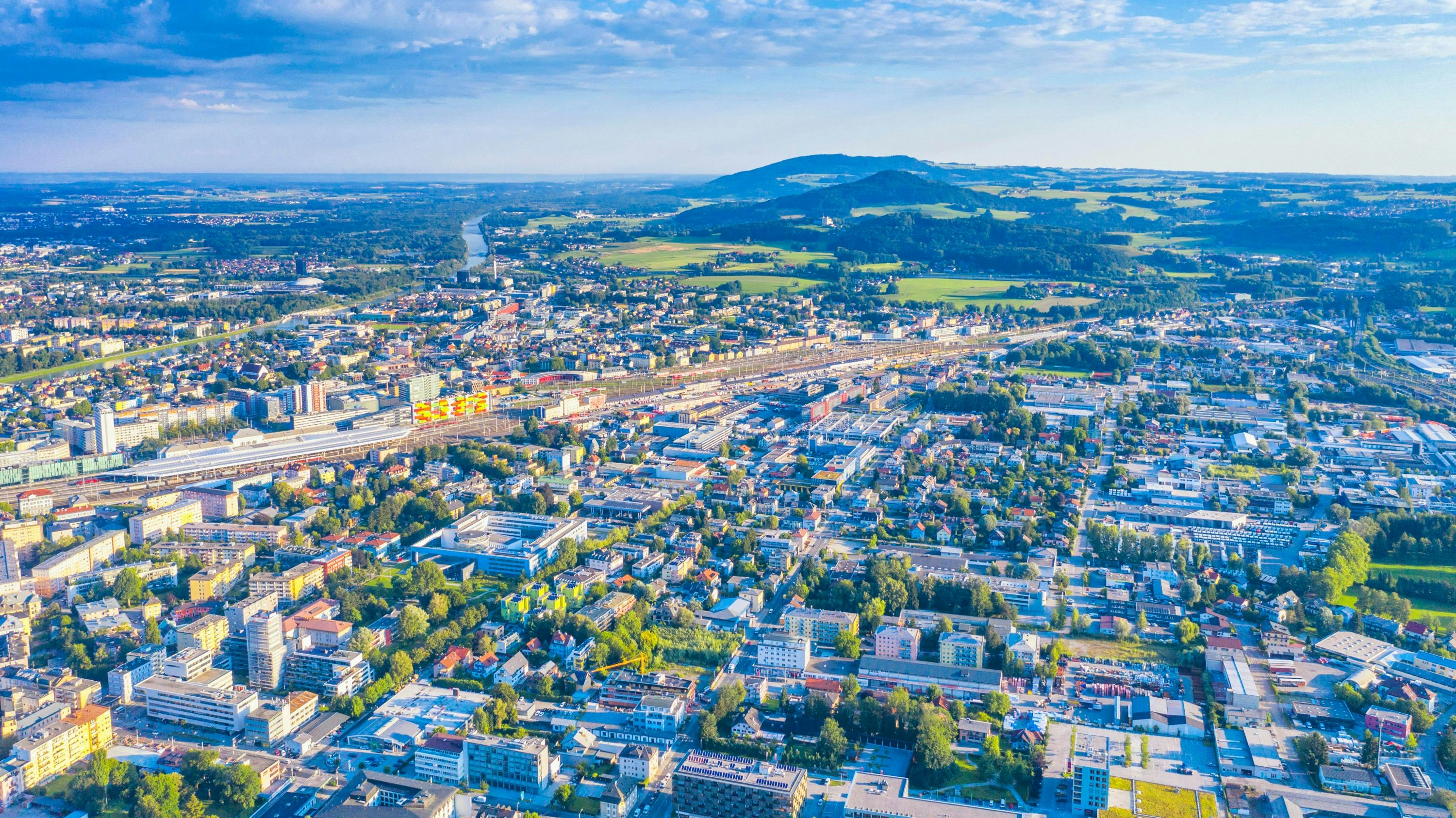 Download von www.picturedesk.com am 14.12.2023 (13:52).  Drohnenaufnahme vom Kapuzinerberg mit Blick auf die Stadtteile Schallmoos mit der Zentrale der Salzburg AG, das Bahnhofsviertel und Elisabethviertel, Itzling, Gnigl und Maria Plain und Bergheim. Im Hintergrund links die Salzach, die hier die Staatsgrenze zu Deutschland und Bayern (links der Salzach) bildet. In der Mitte bildet der Voggenberg und ganz hinten der Haunsberg den Hintergrund. Die Aufnahme entstand früh am Morgen kurz nach Sonnenaufgang - 20200722_PD0952 - Rechteinfo: Rights Managed (RM)