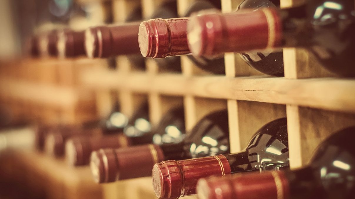 Red wine bottles stacked on wooden racks