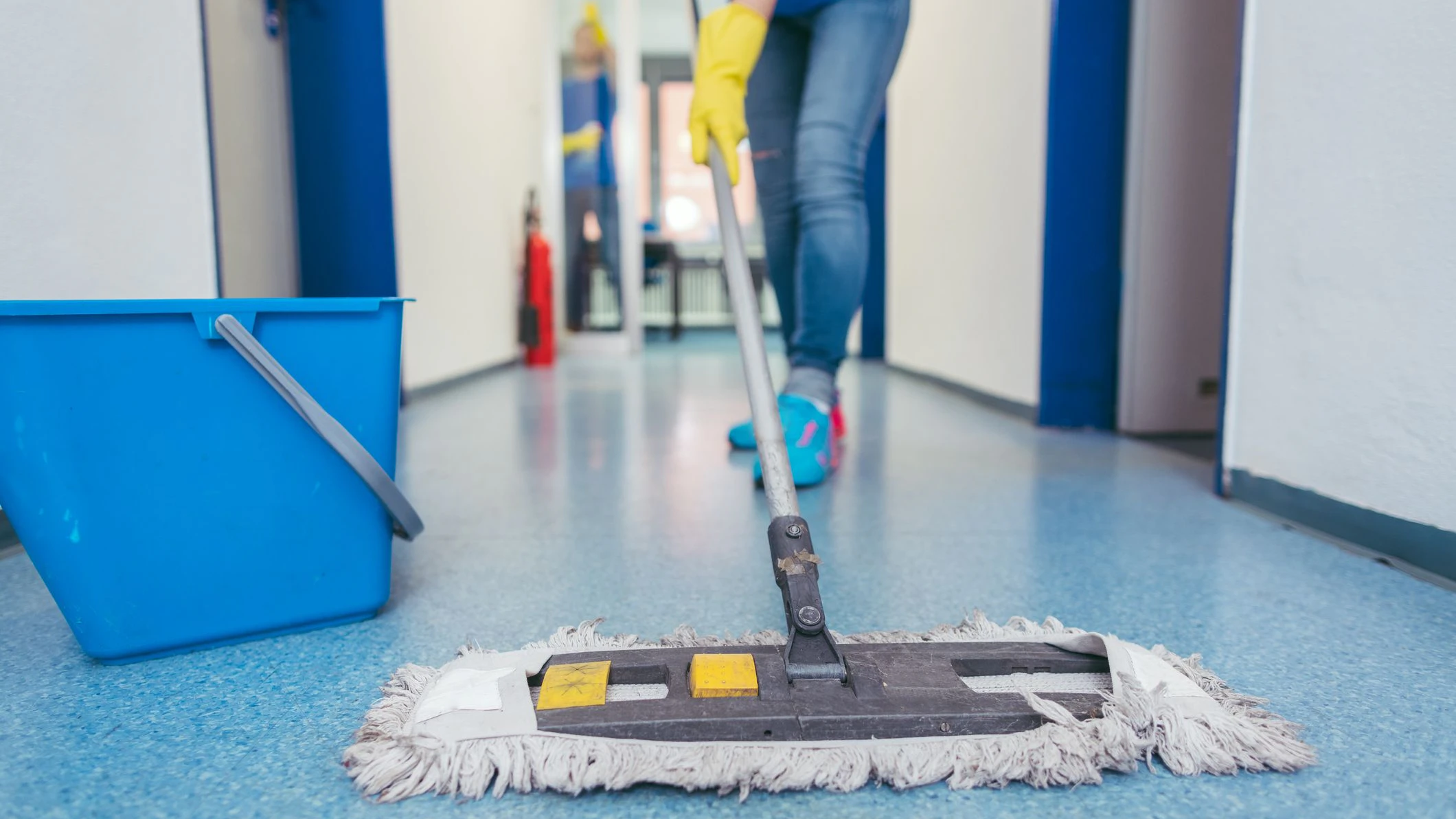 Close-up of cleaners moping the floor of a hall