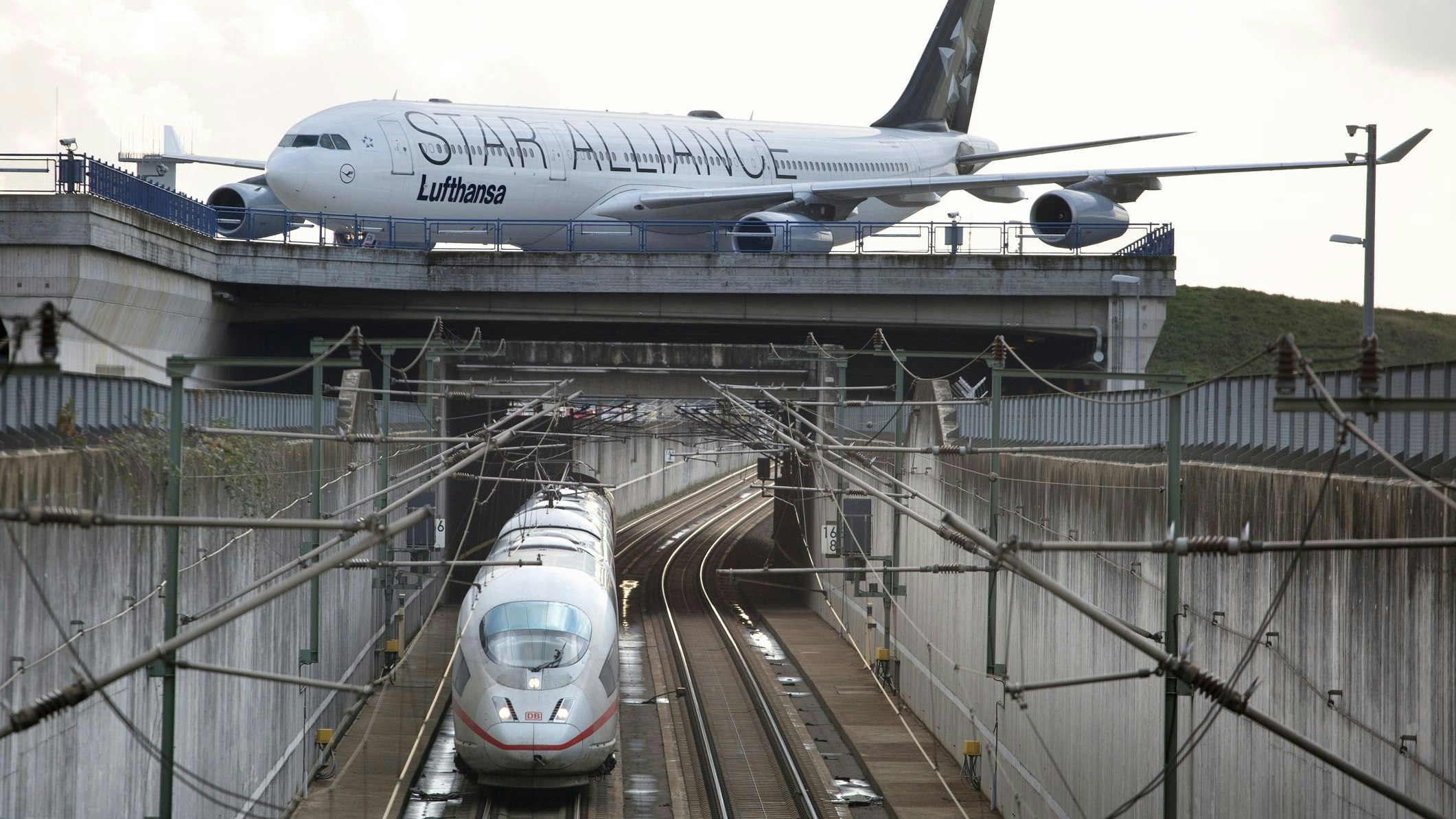 Kelsterbach, Germany - November 19, 2019: Passing German ICE highspeed train and taxiing airplane of Lufthansa/Star Alliance at Frankfurt airport.