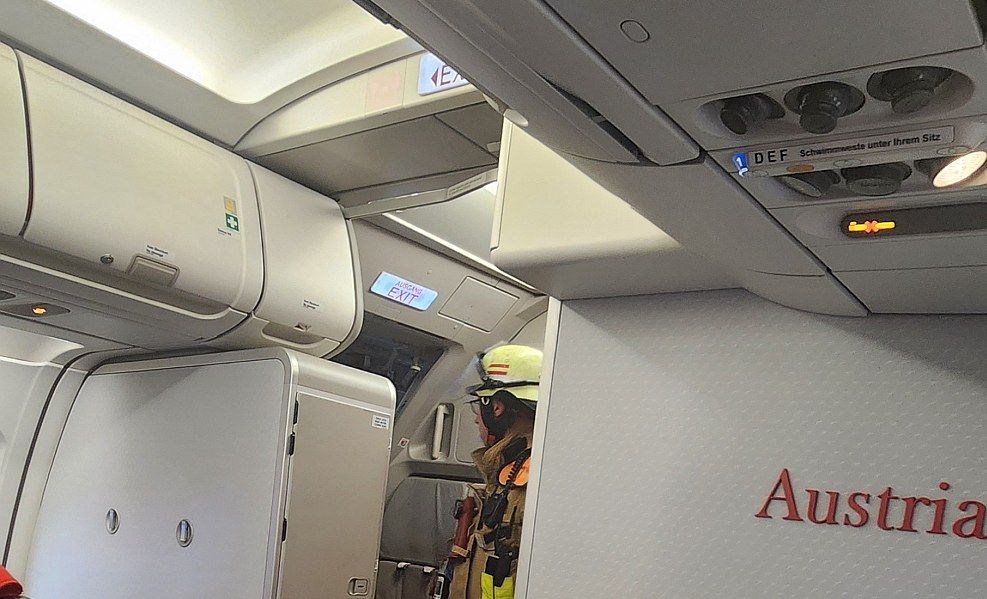 Feuerwehrmänner kontrollieren die AUA-Maschine nach dem Zwischenfall.