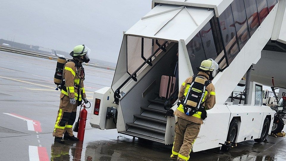 Bilder der Passagiere zeigen, wie Feuerwehrleute das Problem-Flugzeug erwarten.