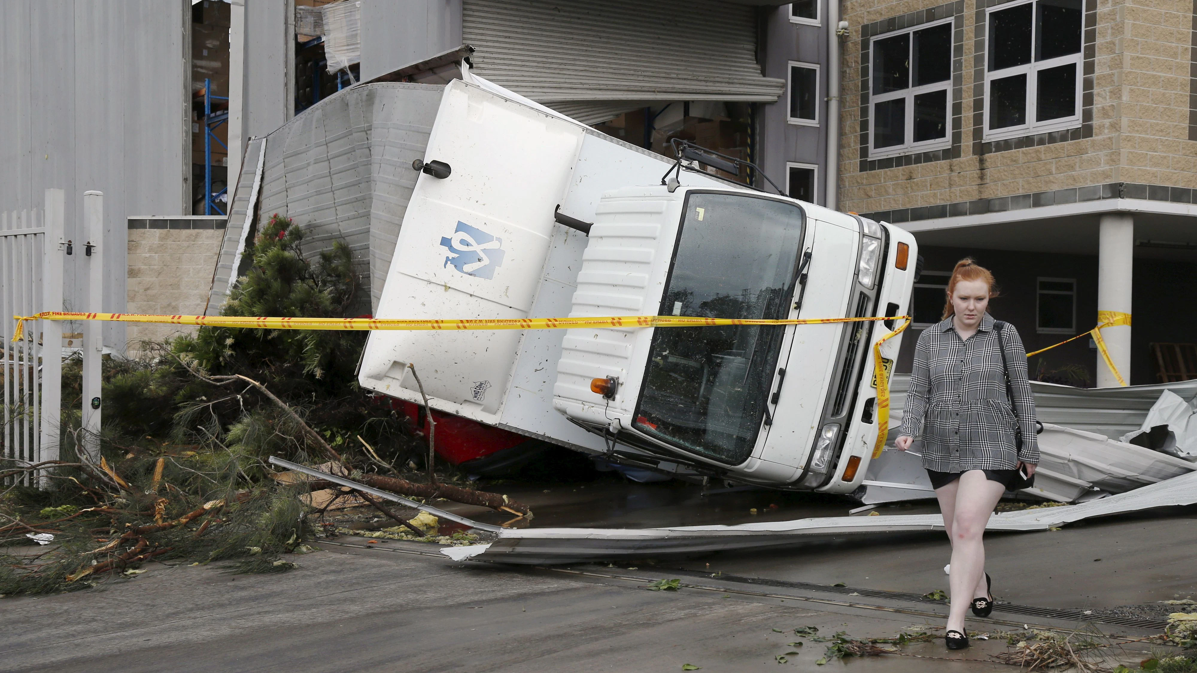 A truck lays overturned onto a car following strong winds at a Kurnell industrial park after a rare tornado hit the Sydney suburb December 16, 2015. REUTERS/Jason Reed