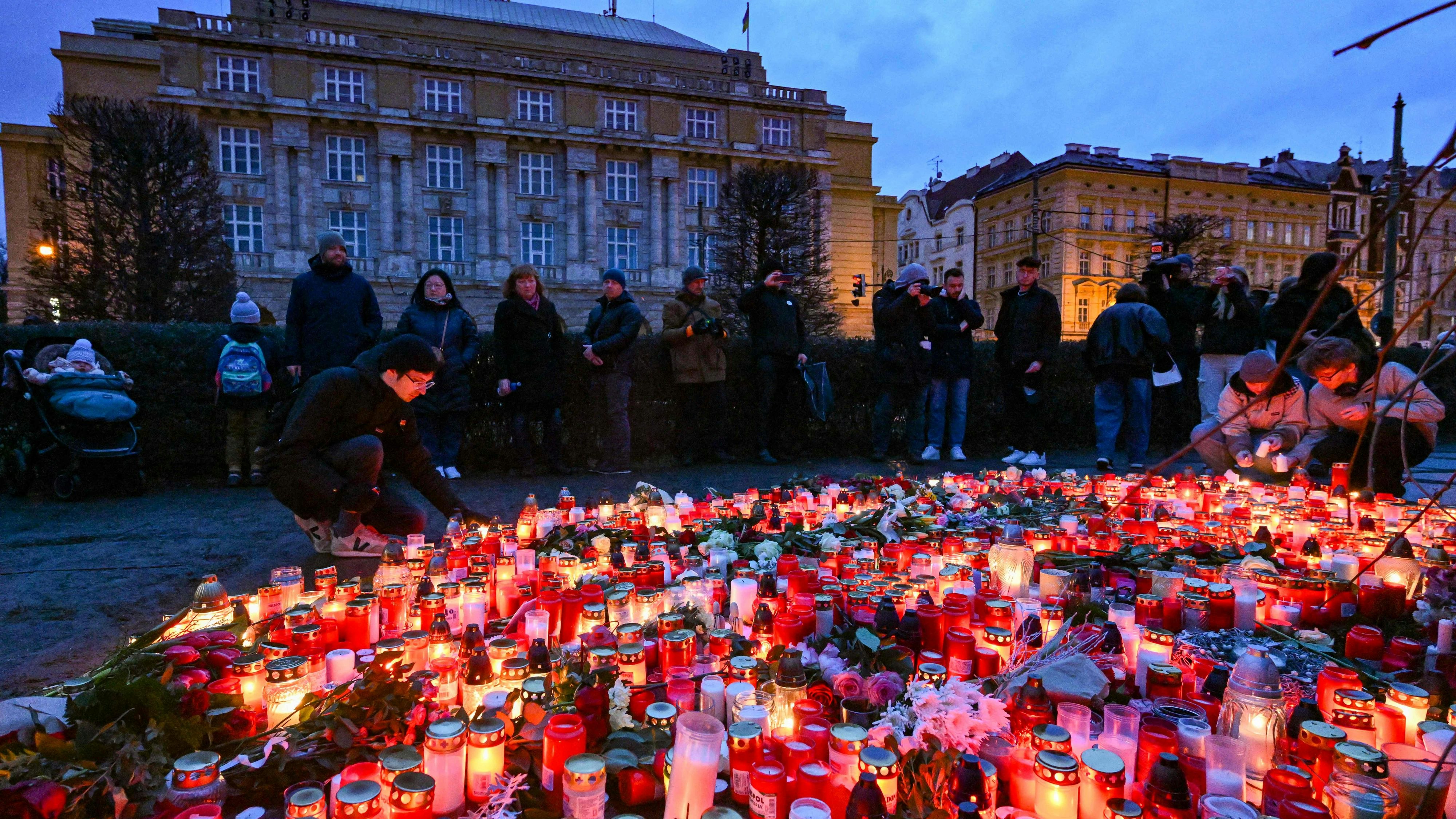 Download von www.picturedesk.com am 27.12.2023 (20:41).  People mourn at a makeshift memorial for the victims outside the Charles University in central Prague, on December 22, 2023, as police investigators kept working on the campus the day after a deadly mass shooting. The gunman who opened fire at Prague's Charles University killed 13 people and then himself, Czech authorities said, revising the toll from 14 victims. Czech authorities sought a motive in the a student's gun attack at the Charles University's Faculty of Arts. The gunman, a 24-year-old student, died during the attack on December 21, 2023. (Photo by Michal Cizek / AFP) - 20231222_PD4420 - Rechteinfo: Rights Managed (RM) Nur für redaktionelle Nutzung! Werbliche Nutzung erfordert Freigabe: bitte schicken Sie uns eine Anfrage.