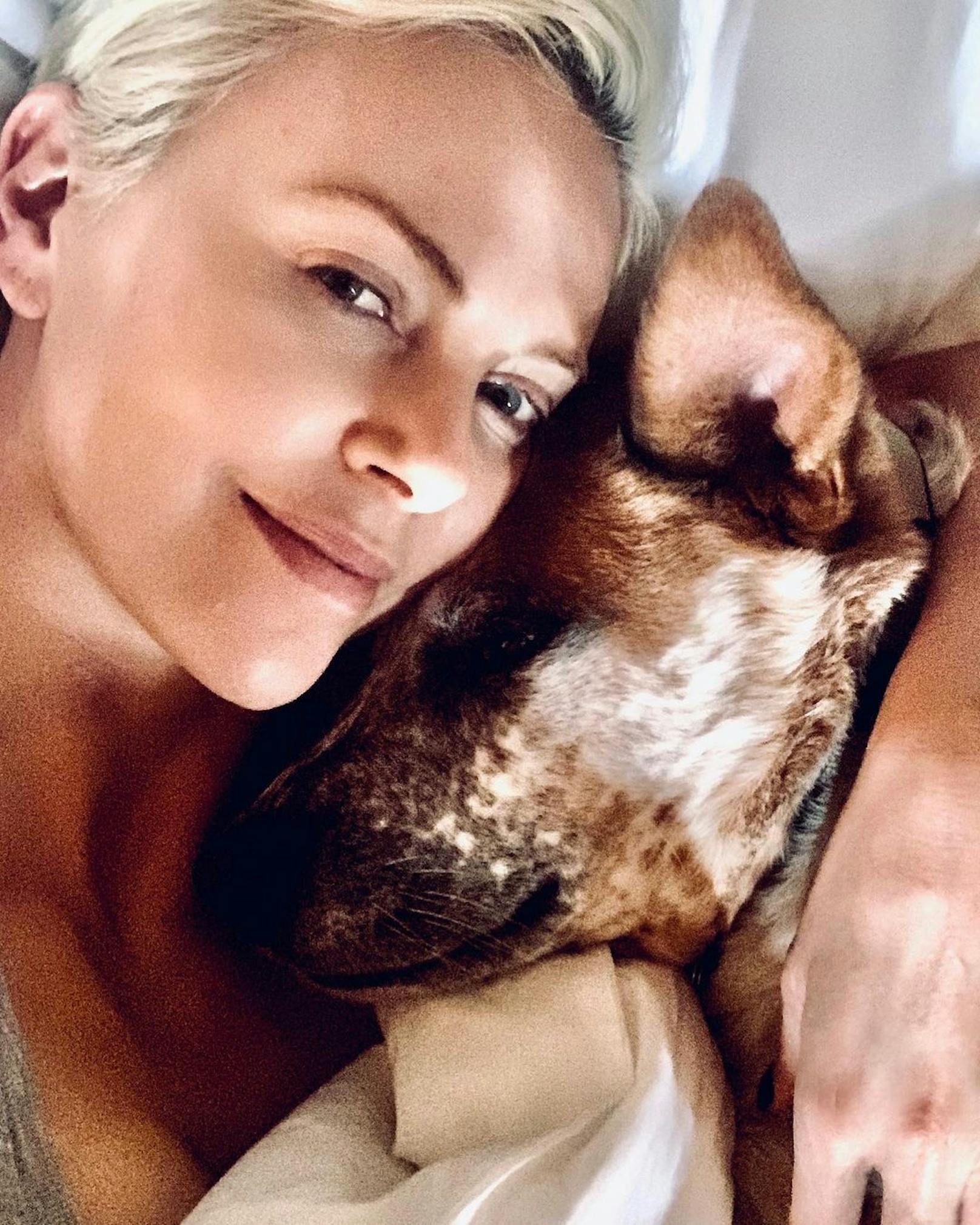 Charlize Theron auf dem Sofa mit ihrem Hund.