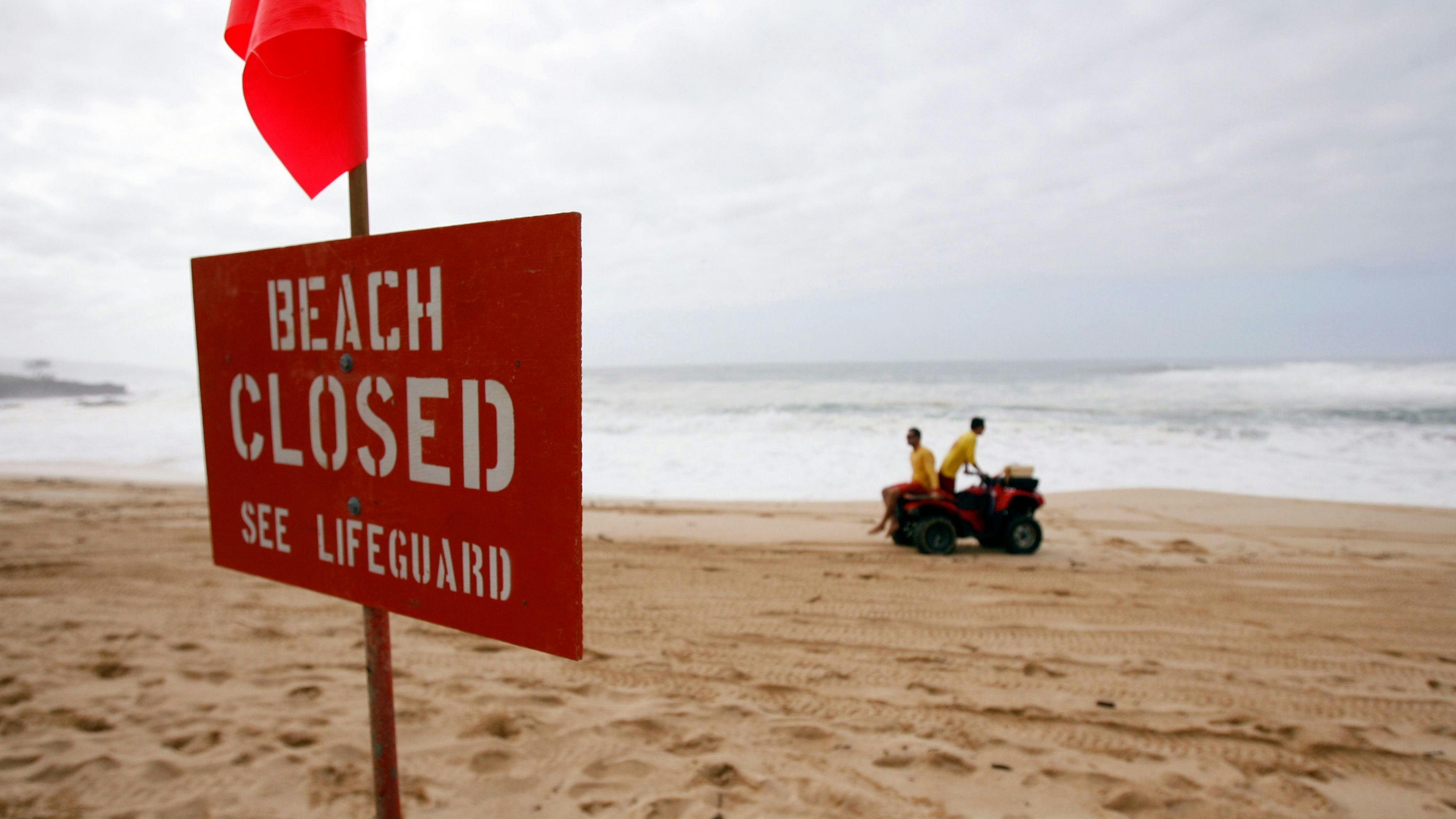 Water Safety Officers patrol the beach on their all-terrain vehicle at Waimea Bay on the north shore of Oahu in Haleiwa, Hawaii December 7, 2009. Waves 50 feet and bigger are expected through Wednesday. The Eddie Aikau Big Wave Invitational surf contest is on hold for tomorrow. REUTERS/Hugh Gentry(UNITED STATES ENVIRONMENT SPORT)