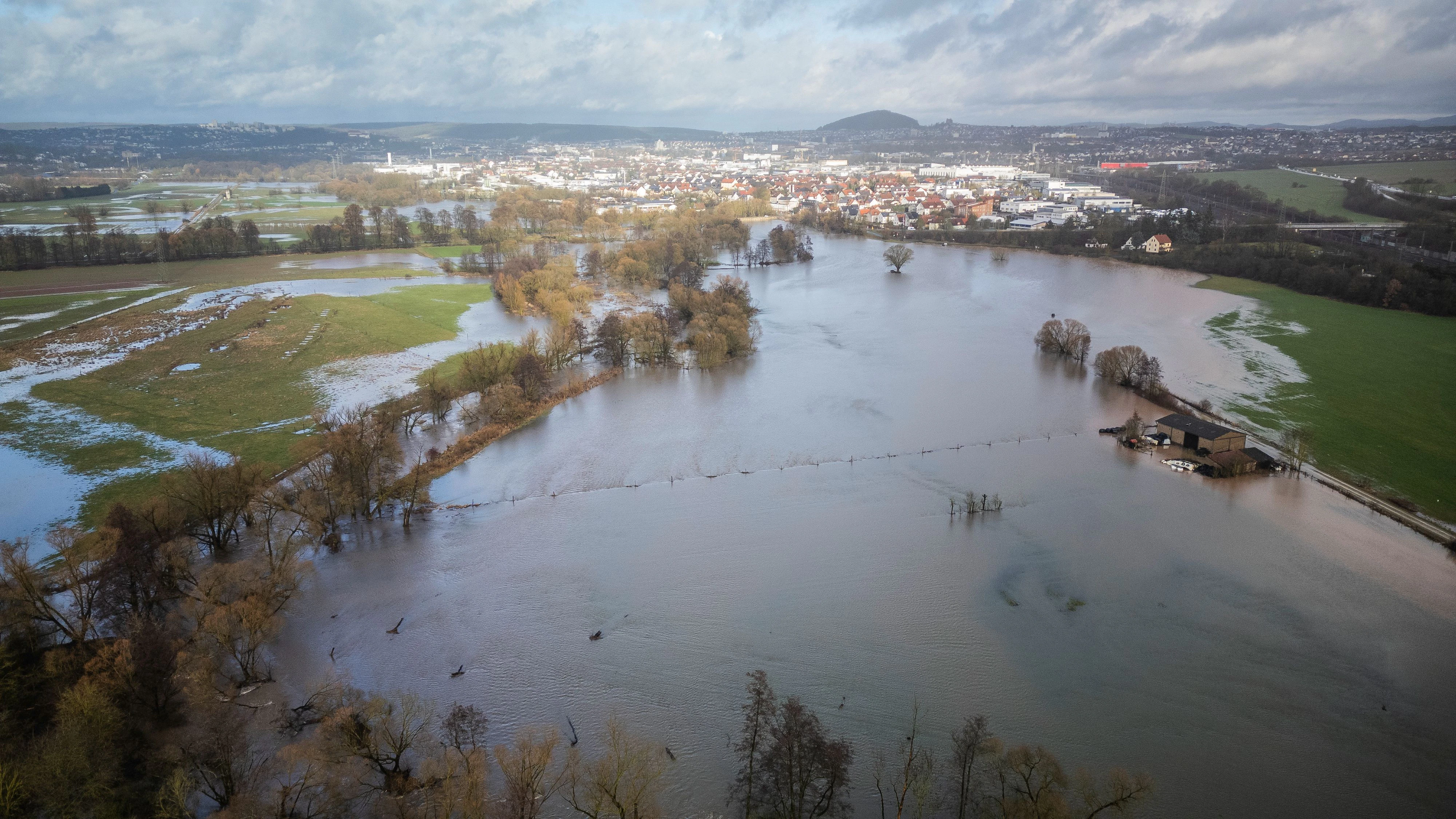 Download von www.picturedesk.com am 03.01.2024 (15:52).  03 January 2024, Hesse, Fulda: The Fulda, which has risen sharply, has burst its banks in the Bronnzell district and spread across the adjacent meadows. The town of Fulda can be seen in the background. After the heavy rainfall on Wednesday and on Thursday night, rivers and streams in eastern Hesse, including the Fulda, burst their banks. At the measuring station in the Fulda district of Bronnzell, the level of the Fulda even rose above the third reporting level, where, according to the state office, there is exceptional flooding. (Photo taken with a drone) Photo: Andreas Arnold/dpa - 20240103_PD4924 - Rechteinfo: Rights Managed (RM)