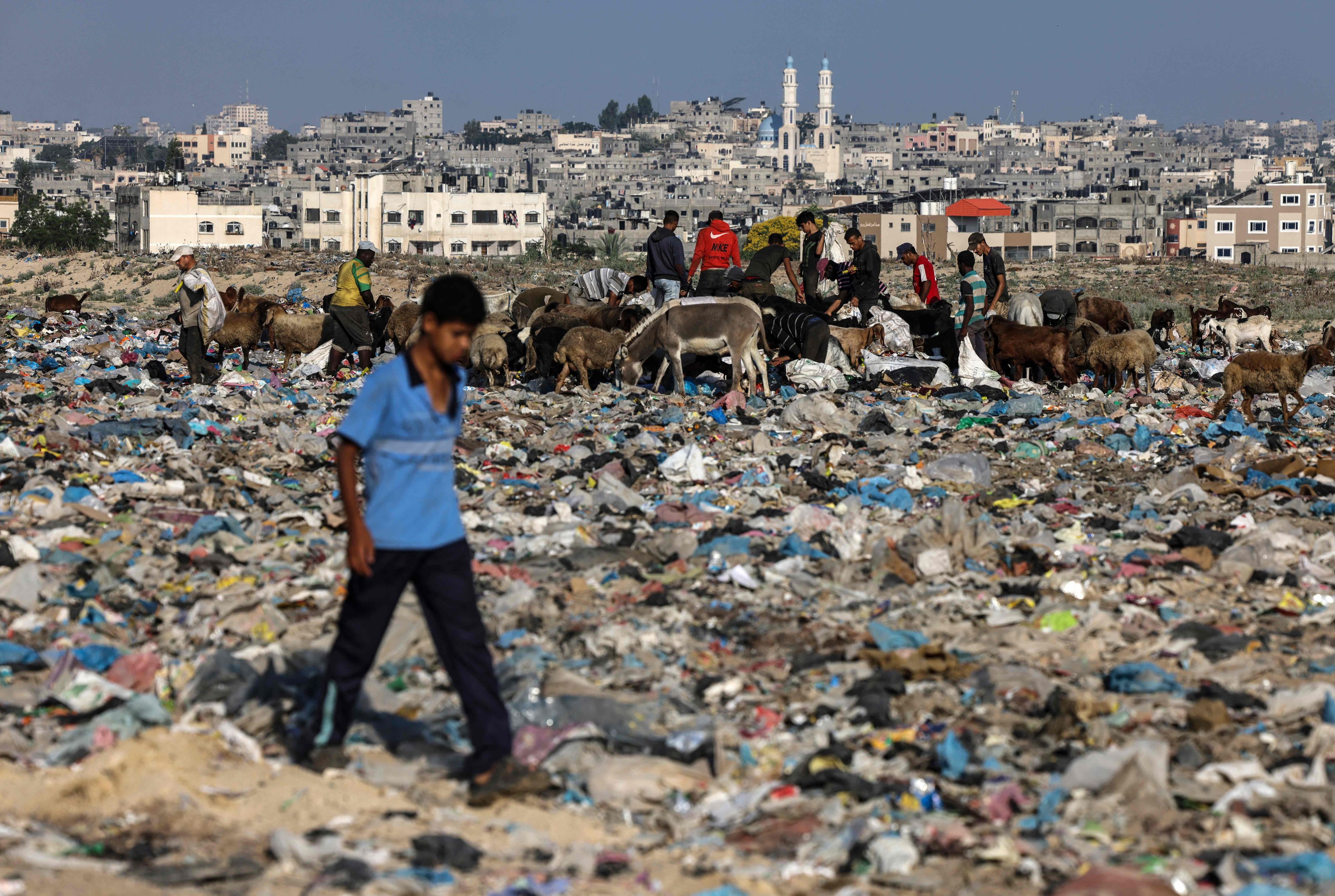 Eine Junge geht über die Müllberge im Gazastreifen. 