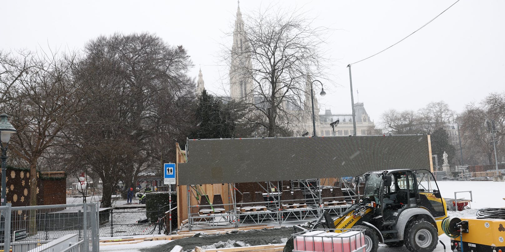 Die Arbeiter bauen Wiens größten Eislaufplatz trotz Schneefalls auf. 