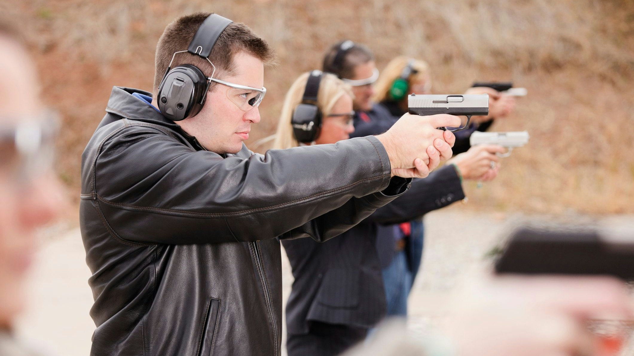 A group of people practicing at the gun range. Photographed on location at a shooting range.