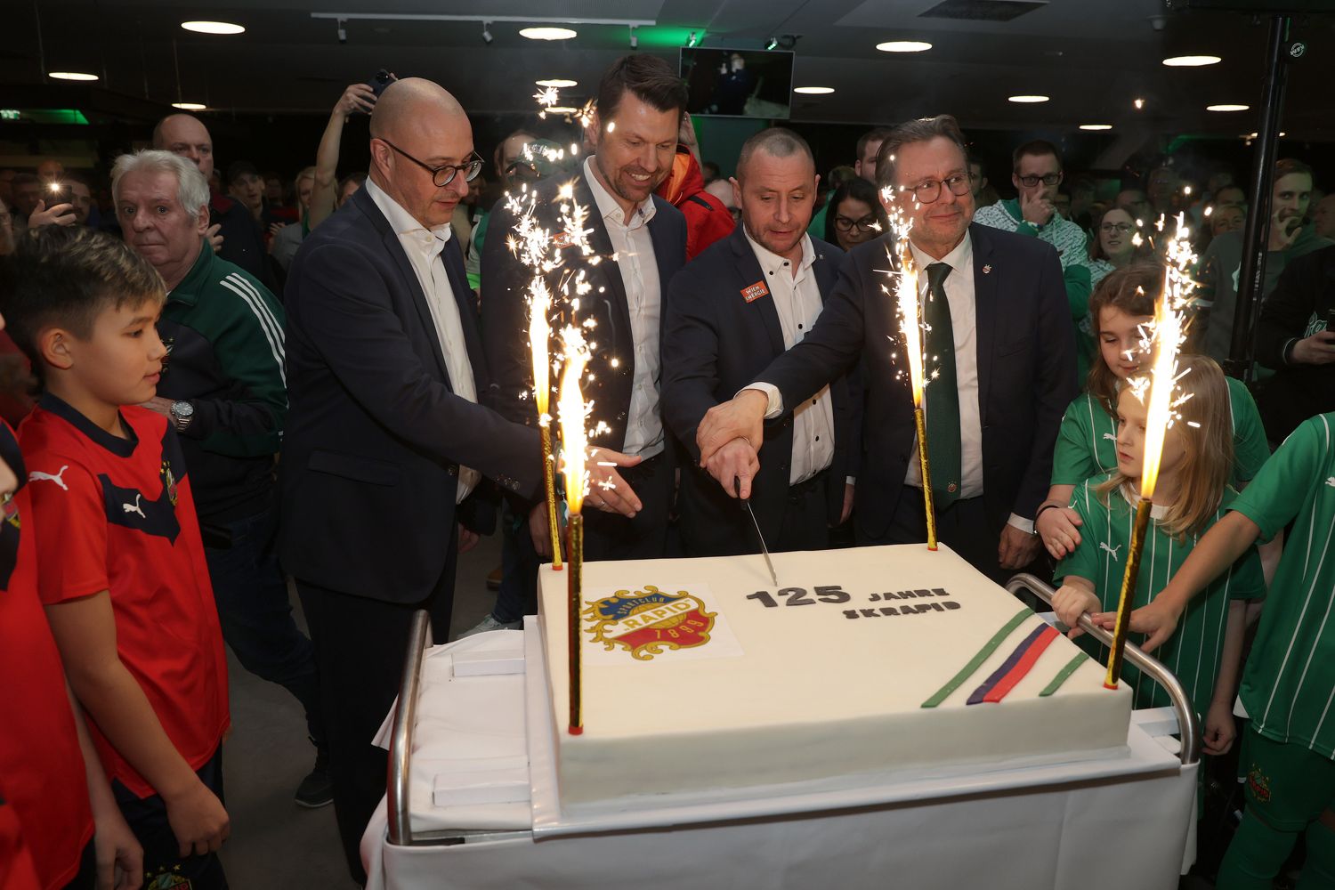 Alexander Wrabetz führt die Hand von Geschäftsführer Steffen Hofmann beim Torte-Anschneiden.