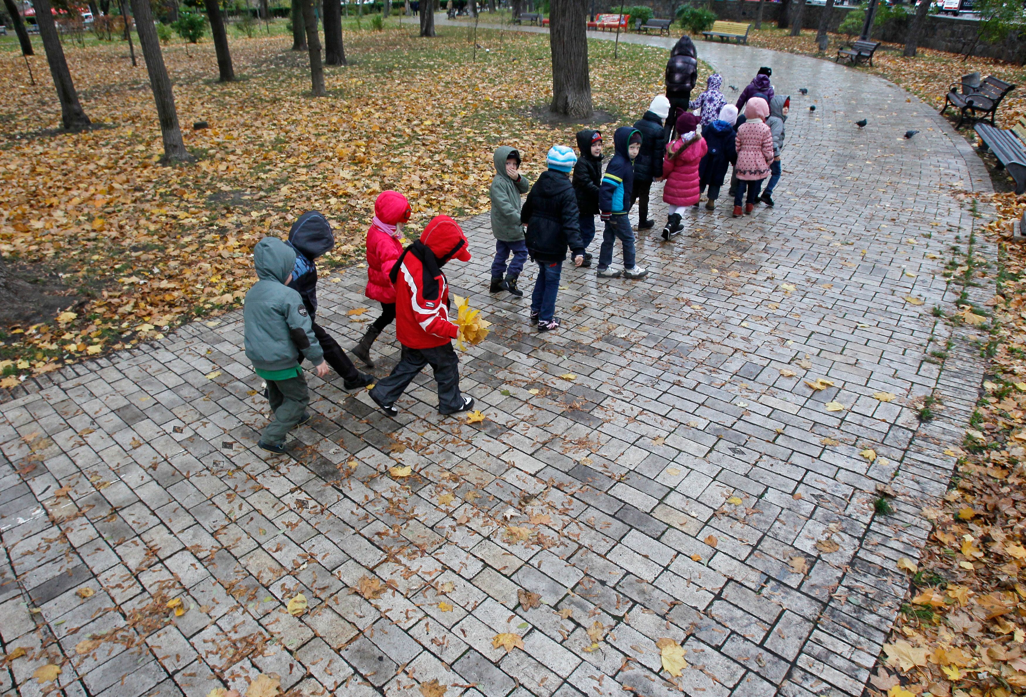 Diese Kinder trotzen dem Regen bei einem Spaziergang in Kiew. Rund 20.000 andere Kinder sollen nach Russland verschleppt worden sein. 