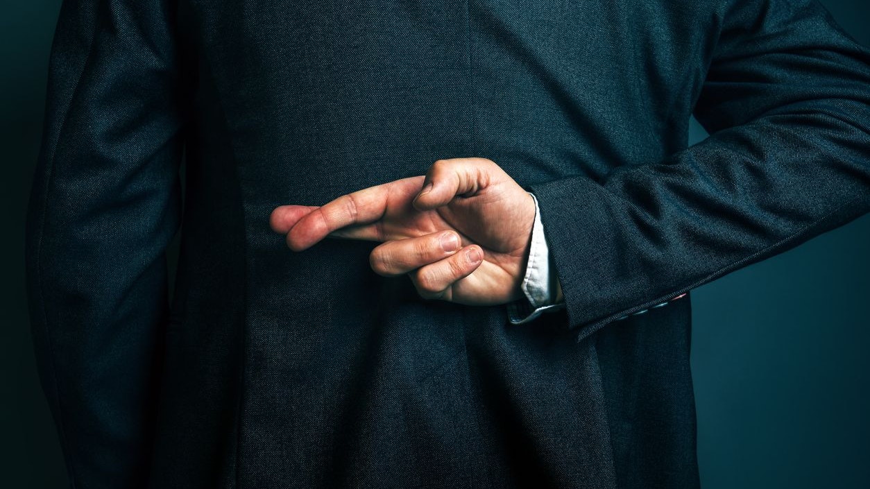 Dishonest businessman telling lies, lying businessperson holding fingers crossed behind his back