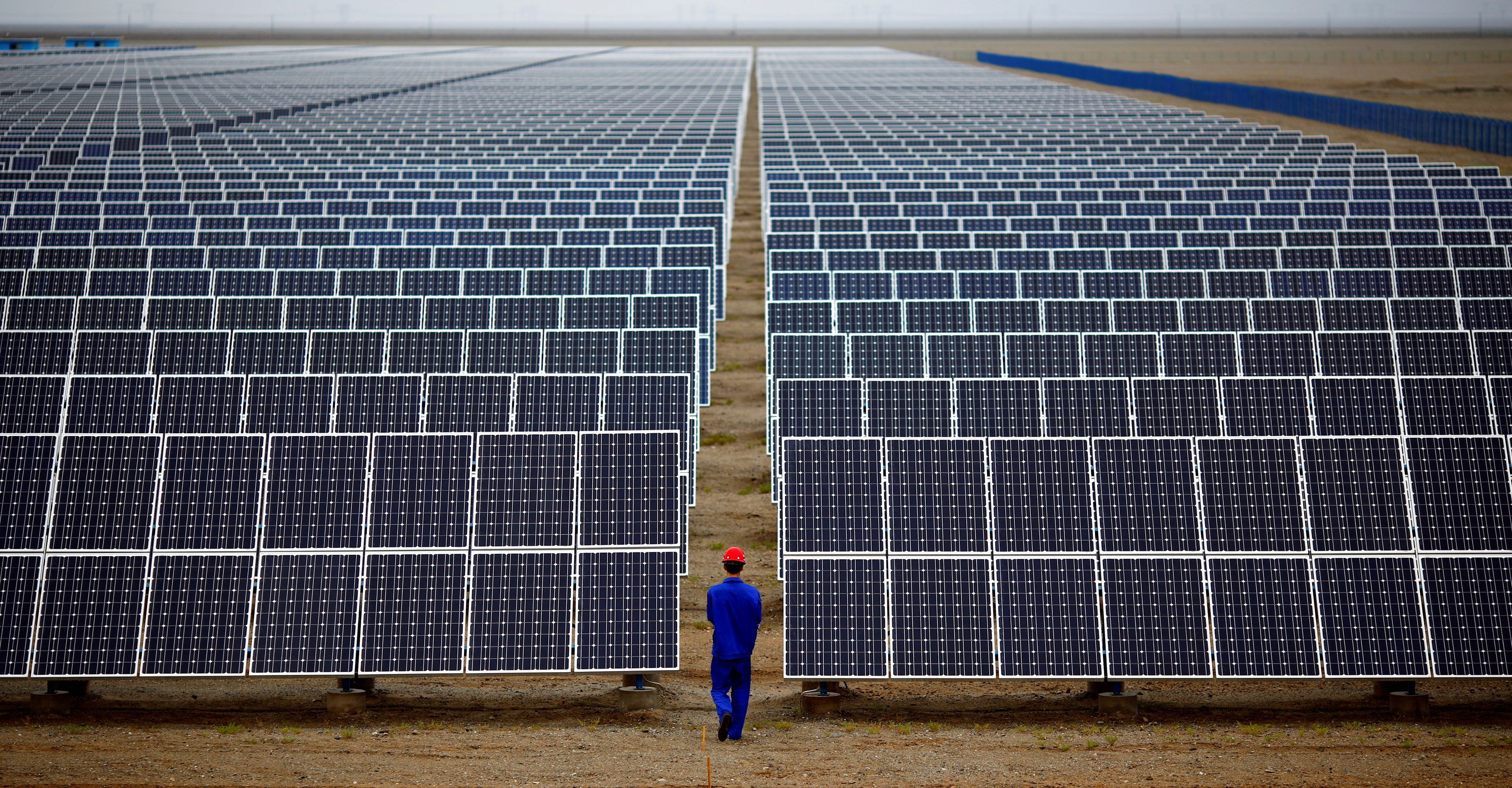 Ein Arbeiter inspiziert Solarmodule in einem Solarpark in Dunhuang, 950 km nordwestlich von Lanzhou, Provinz Gansu.