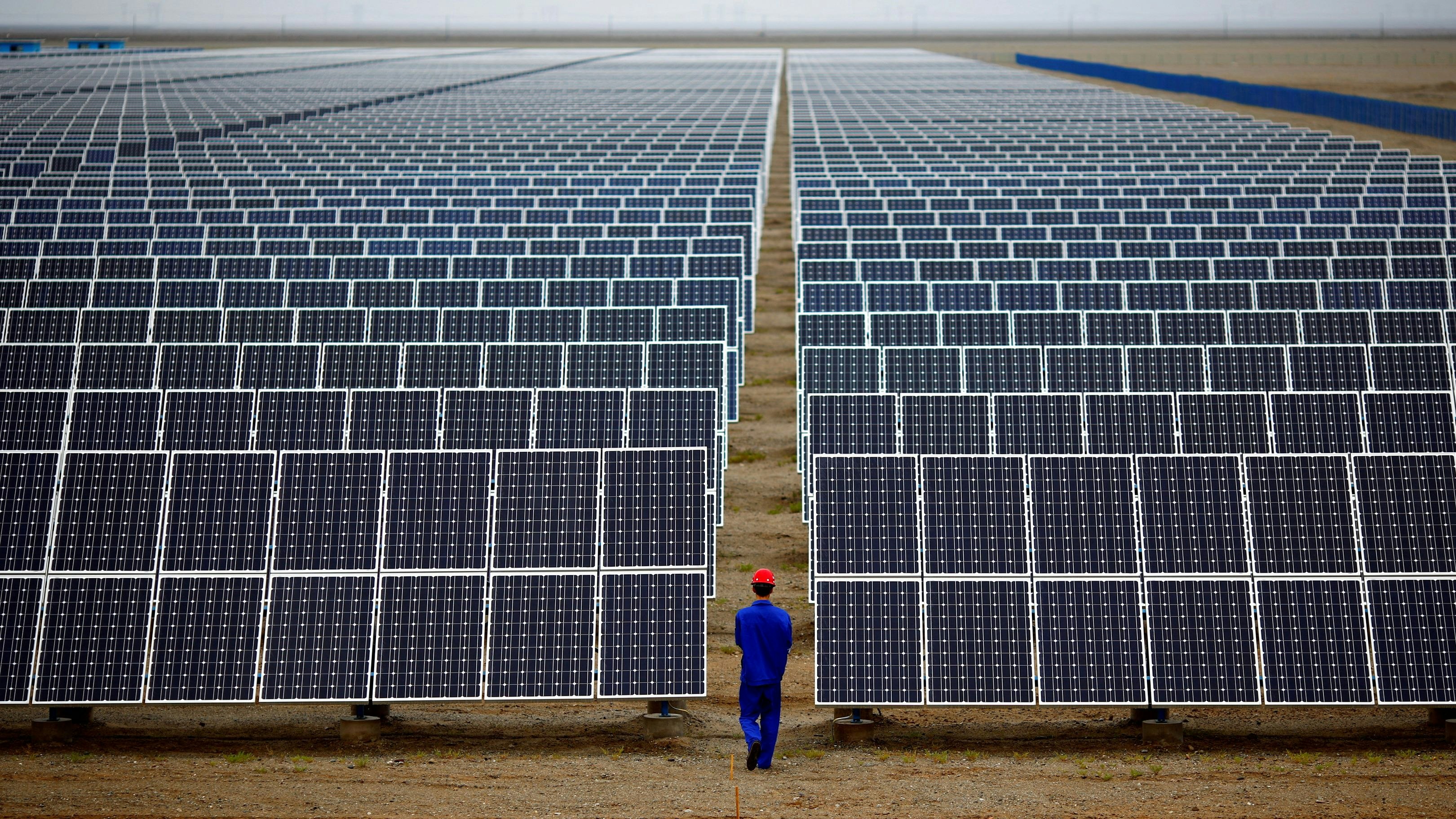 FILE PHOTO: A worker inspects solar panels at a solar Dunhuang, 950km (590 miles) northwest of Lanzhou, Gansu Province September 16, 2013. REUTERS/Carlos Barria/File Photo